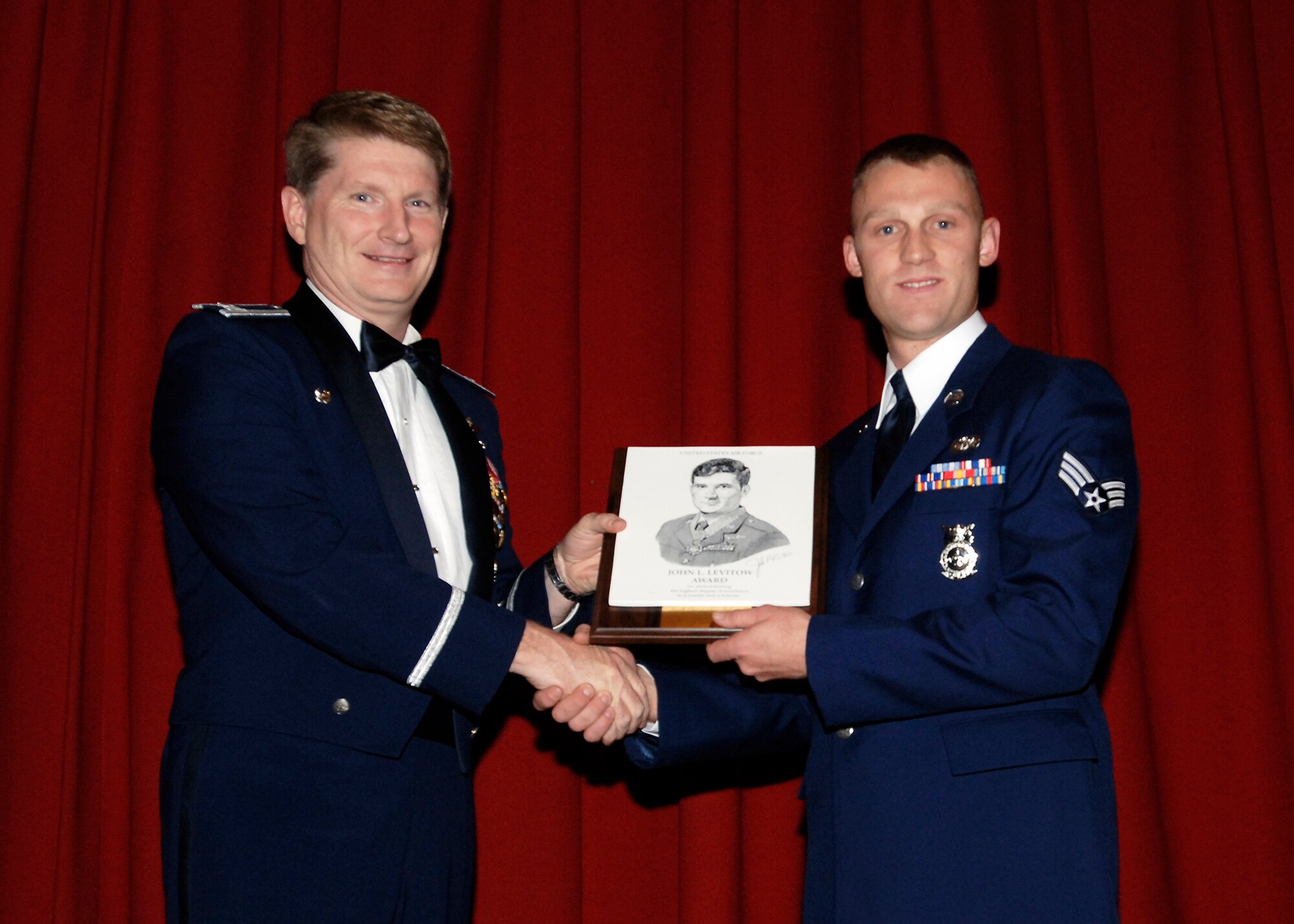 FAIRCHILD AIR FORCE BASE, Wash. – Col. Robert Thomas, 92nd Air Refueling Wing commander, presents Senior Airman Christopher Solomon, 92nd Civil Engineer Squadron fire fighter, with the John Levitow Award during the Airman Leadership School graduation Oct. 9. The prestigious Levitow award is the highest professional military education award given in enlisted PME classes, indicating excellence in academics, leadership and peer standing. (U.S. Air Force photo / Airmen 1st Class Melissa Barnett)