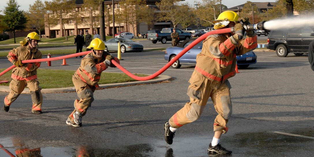 First Lieutenants Jeremy Powell and Nicholas Ringo and Staff Sgt. Bryan Costerisan, from the 1st Helicopter Squadron, rush to extinguish a simulated fire blaze during the Firefighter Challenge at Andrews Oct. 10. Lieutenants Powell and Ringo and Staff Sgt. Costerisan are part of the 1st Heli team. The Firefighter Challenge is an annual event that promotes morale, team work and physical prowess among military personnel assigned here at Andrews. The Firefighter Challenge is an annual event that promotes morale, team work and physical prowess among military personnel assigned here at Andrews.  (U.S. Air Force photo/Senior Airman Giang Nguyen)