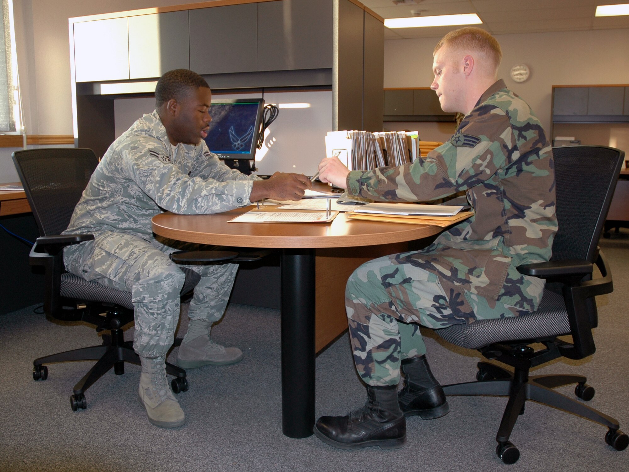 Airman 1st Class Timaria Mckay, 341st Force Support Squadron force management technician, assists Senior Airman Jonathan Griepp with outproccessing paperwork at the Military Personnel Flight in Building 1191 Oct. 9. (U.S. Air Force photo/Airman 1st Class Dillon White) 