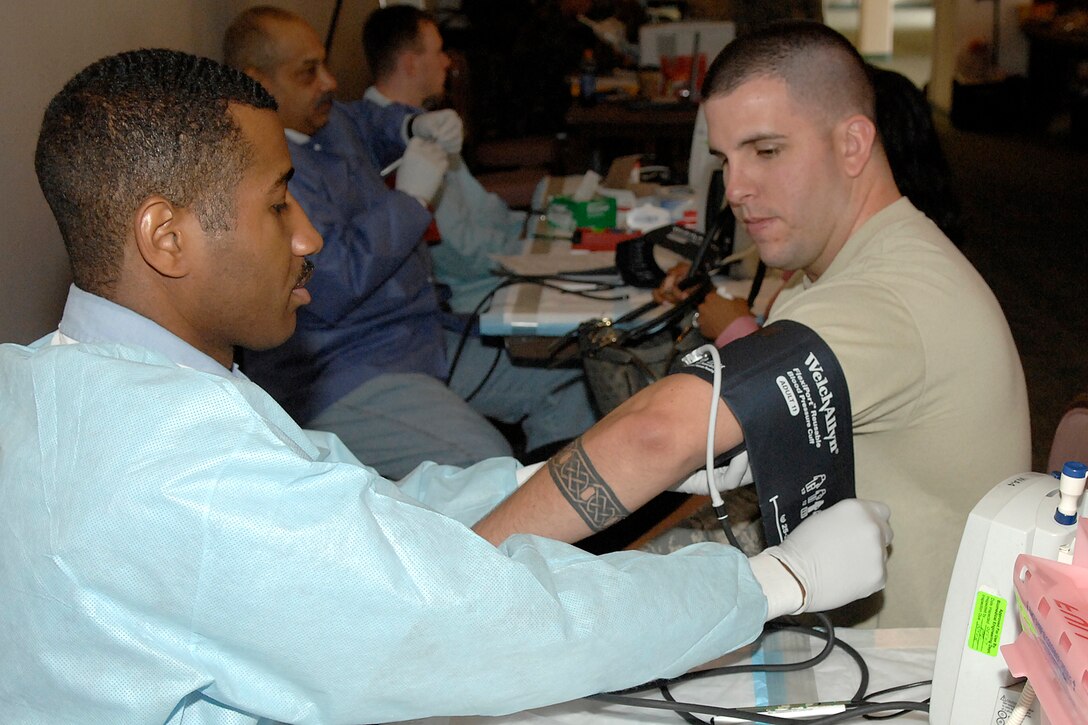 Hospital Corpsman Second Class Alan Frazler, a Leading Petty Officer Mobile Donor Team from the Armed Services Blood Bank Center Bethesda, obtains blood pressure from Staff Sgt. Robert Lowe, a unit training manager from the 89th Aerial Port Squadron, to ensure good health condition prior to the blood donation process at Andrews Oct. 8. The purpose of the blood drive is to build up the reserve stock and gather rare blood types. (U.S. Air Force photo/Senior Airman Giang Nguyen)