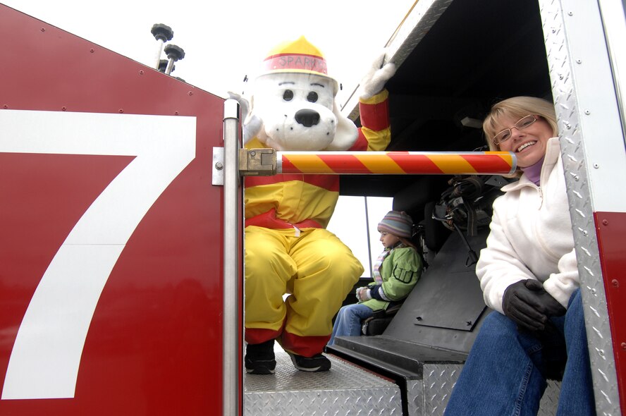 MINOT AIR FORCE BASE, N.D. – Erica Harner, wife of Lt. Col. Monte Harner, 5th Civil Engineer Squadron commander, poses with the Minot AFB fire department’s mascot, Sparky, here Oct. 10 during the 2008 Fire Prevention Week parade.  The purpose of the first-ever event is to remind base residents to take proper precautions to help prevent fires and to have a plan in the event of a fire.  Fire Prevention Week took place nationwide Oct. 5 to 11. (U.S. Air Force photo by Senior Airman Kelly Timney)