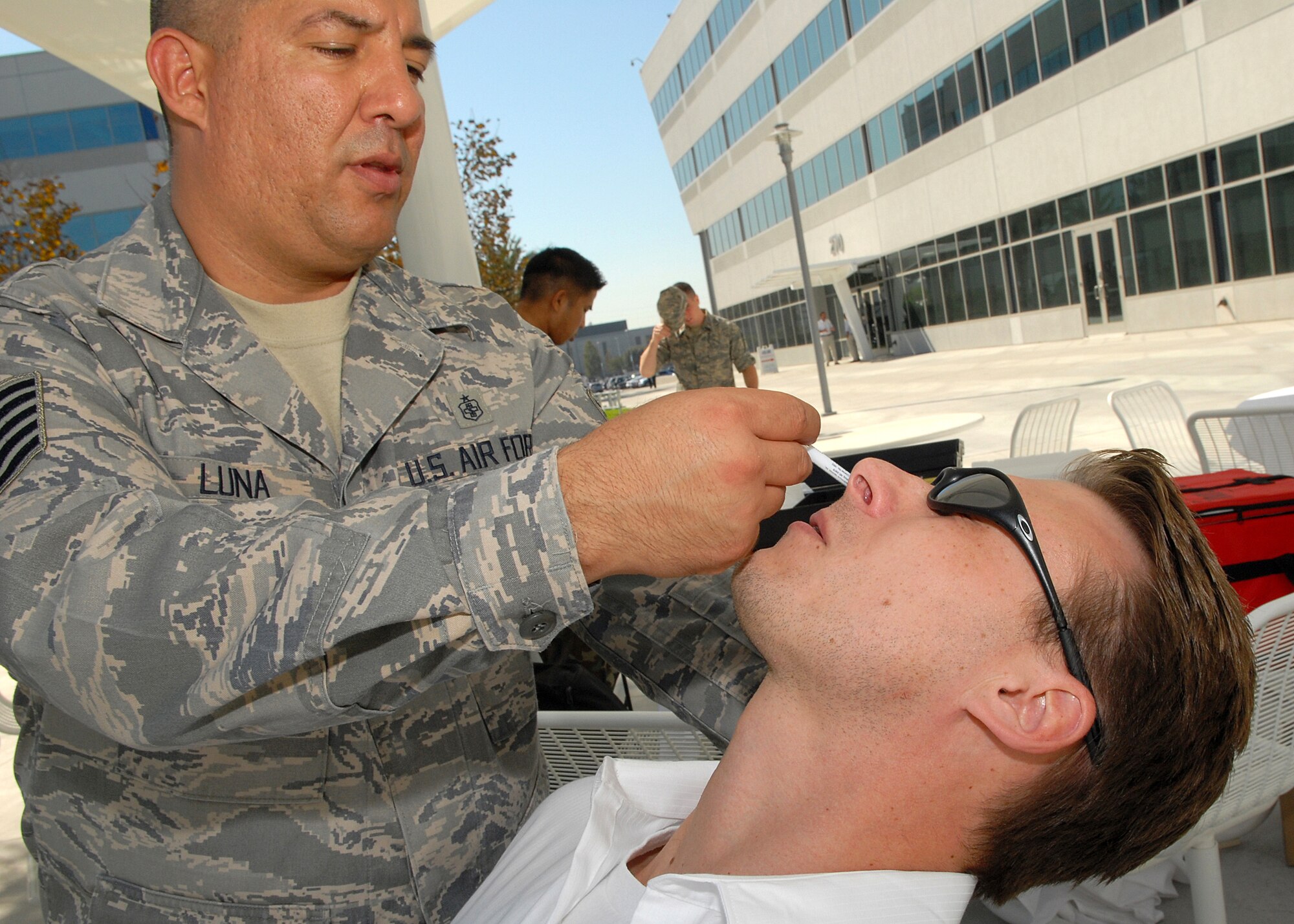 Tech. Sgt. James Luna, 61st Medical Group, administers a flu vaccine in the form of a nasal mist to base photographer Stephen Schester (who set up his camera for this picture and also took the opportunity to get vaccinated), Oct 16. The flu vaccination clinic for base personnel was held in the Schriever Complex Courtyard.  It's  also available at the Immunization Clinics at El Segundo and Fort MacArthur.  Call 310-653-6607 for hours.  Flu vaccination is mandatory for all Air Force personnel by Dec. 5.  The vaccines are offered to all Active Duty, Reserve, Guard, DoD civilians, retirees, and family members.  (Photo by Stephen Schester)