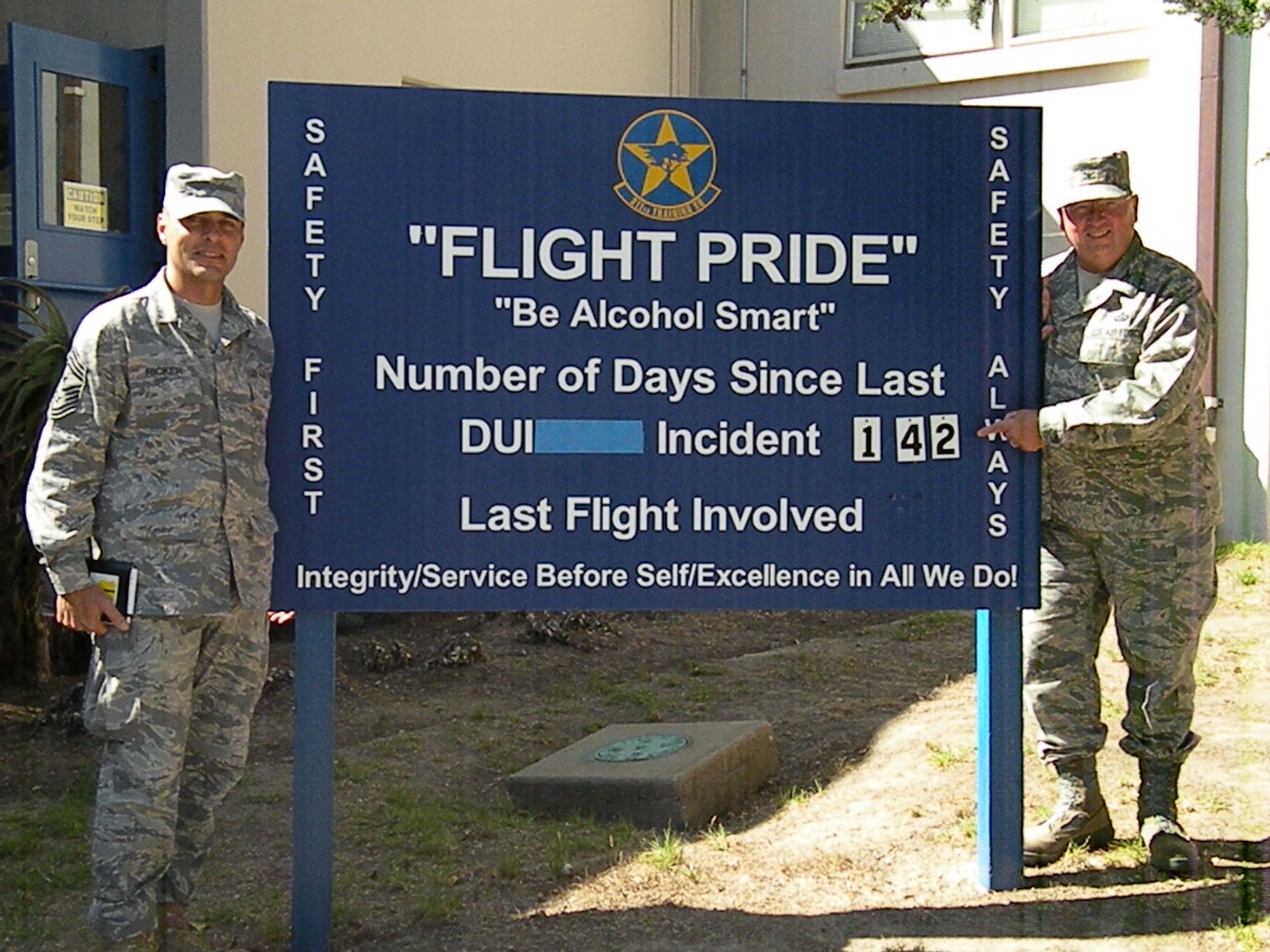 Chief Master Sgt. Frederick Ricker, 17th Training Wing command chief master sergeant, and Col. Richard Ayres, 17th TRW commander, stand beside the squadron Flight Pride board Oct. 9 at the Presidio of Monterey, Calif., as the 311th and 314th Training Squadrons reached 142 days without an incidence of driving under the influence of alcohol. The squadrons reached 150 days without a DUI today. (U.S. Air Force photo by Staff Sgt. Alyssa Gerth)