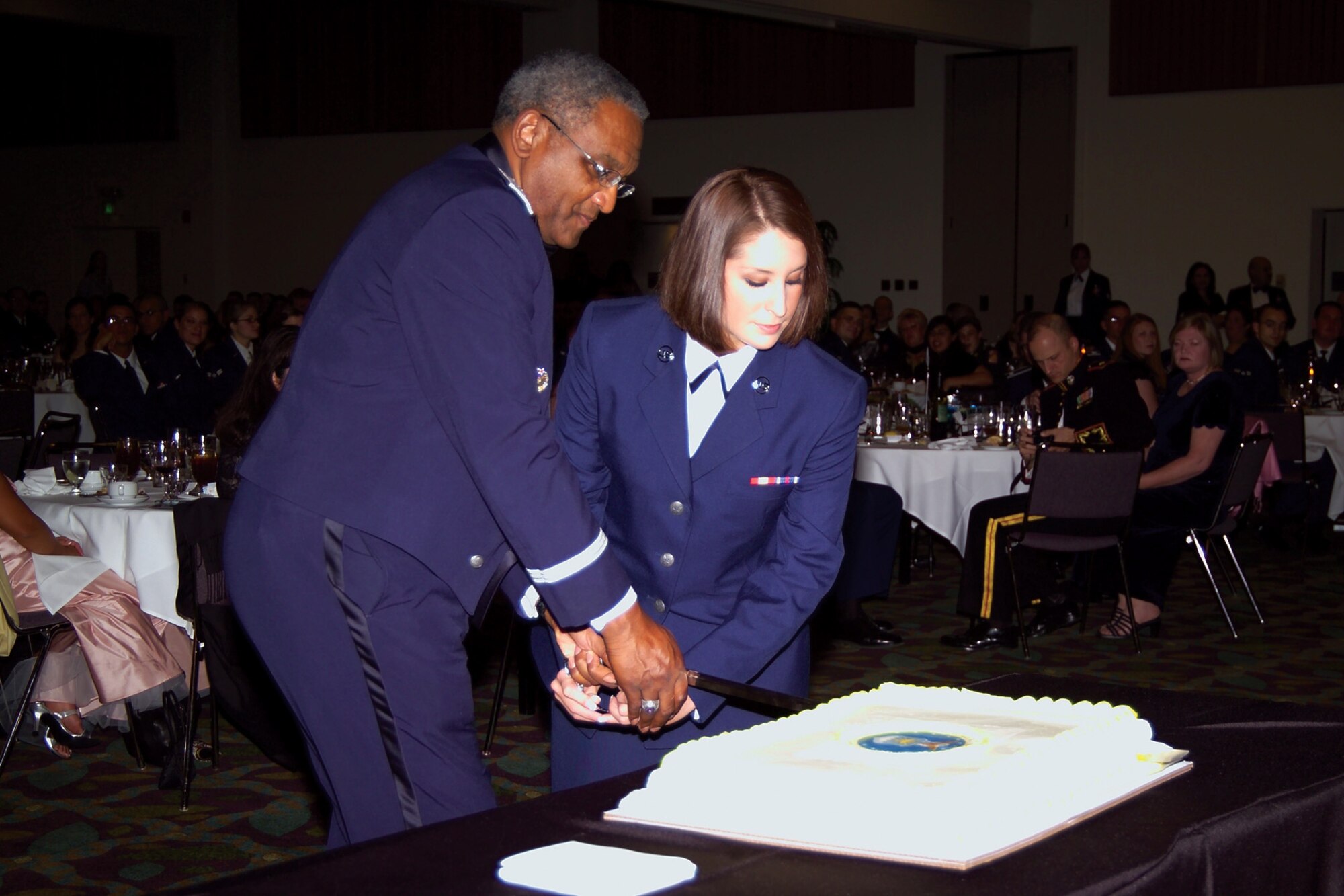 Major General Alfred Flowers, 2nd Air Force commander, and Airman Basic Lauren Arias, 311th Training Squadron, cut the cake as the oldest and youngest attendees at the Presidio of Monterey Air Force Ball Oct. 11. (U.S. Air Force photo by Staff Sgt. Alyssa Gerth)