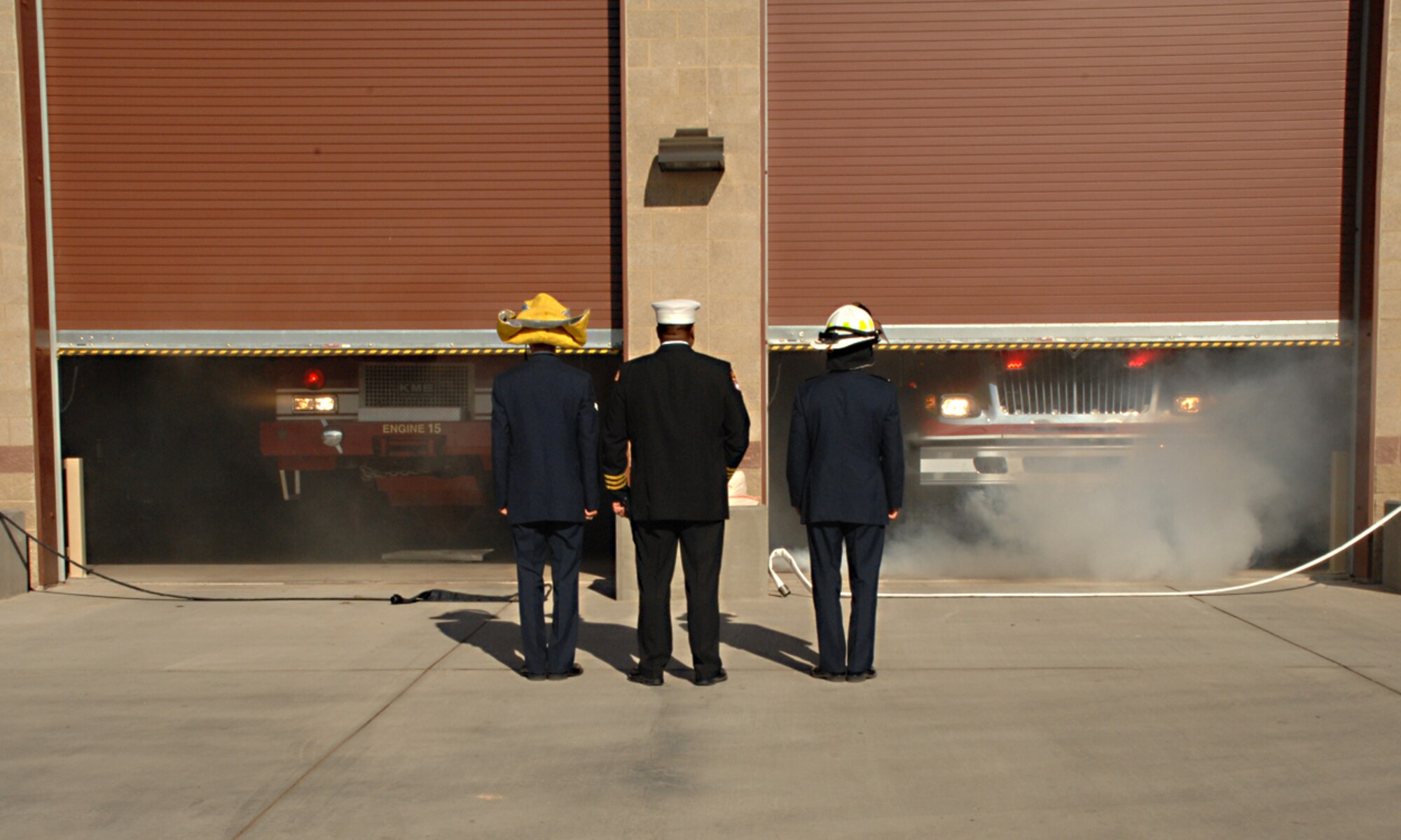 Airman 1st Class Kenneth Nixon, firefighter assigned to the 49th Civil Engineer Squadron, Mr. Dean DeGuzman, assistant chief for operations assigned to the 49th CES and Col. Jeff Harrigian, 49th Fighter Wing commander, wait for the bay doors to open completely, signifying the grand opening of Fire Station 1 at Holloman Air Force Base, N.M., October 9. (U.S. Air Force photo/ Senior Airman Tiffany Trojca) 