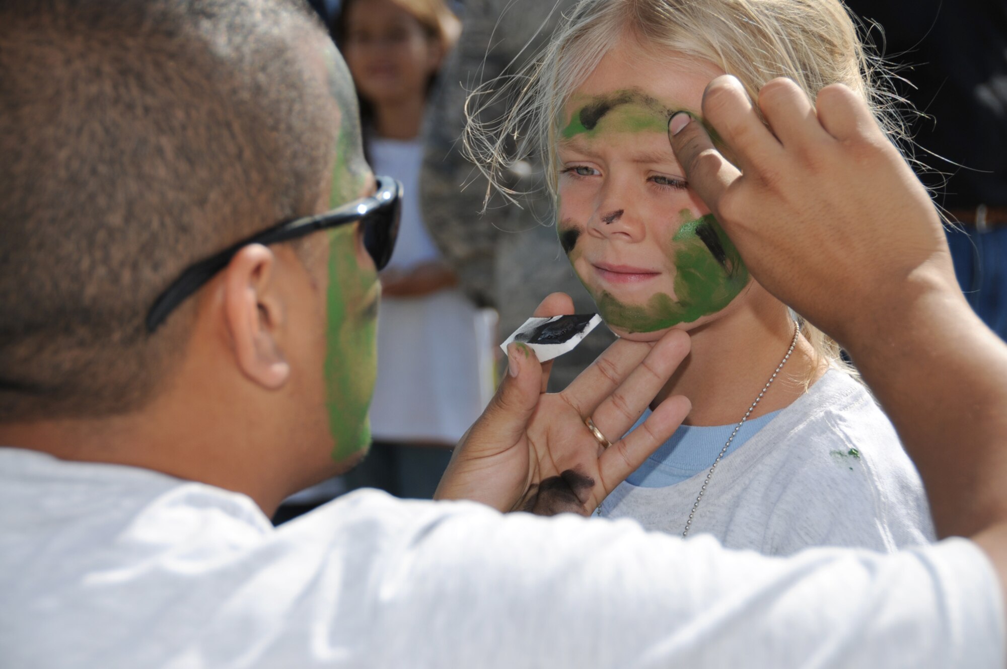 Tech. Sgt. Elvin Muniz, 81st Dental Squadron, paints Hannah Cole’s face during Saturday’s Operation Hero program which introduces children to the deployment process.  Hannah, 7, is the daughter of Maj. Rich and Cheryl Cole, 81st Force Support Squadron commander.  (U.S. Air Force photo by Kemberly Groue)