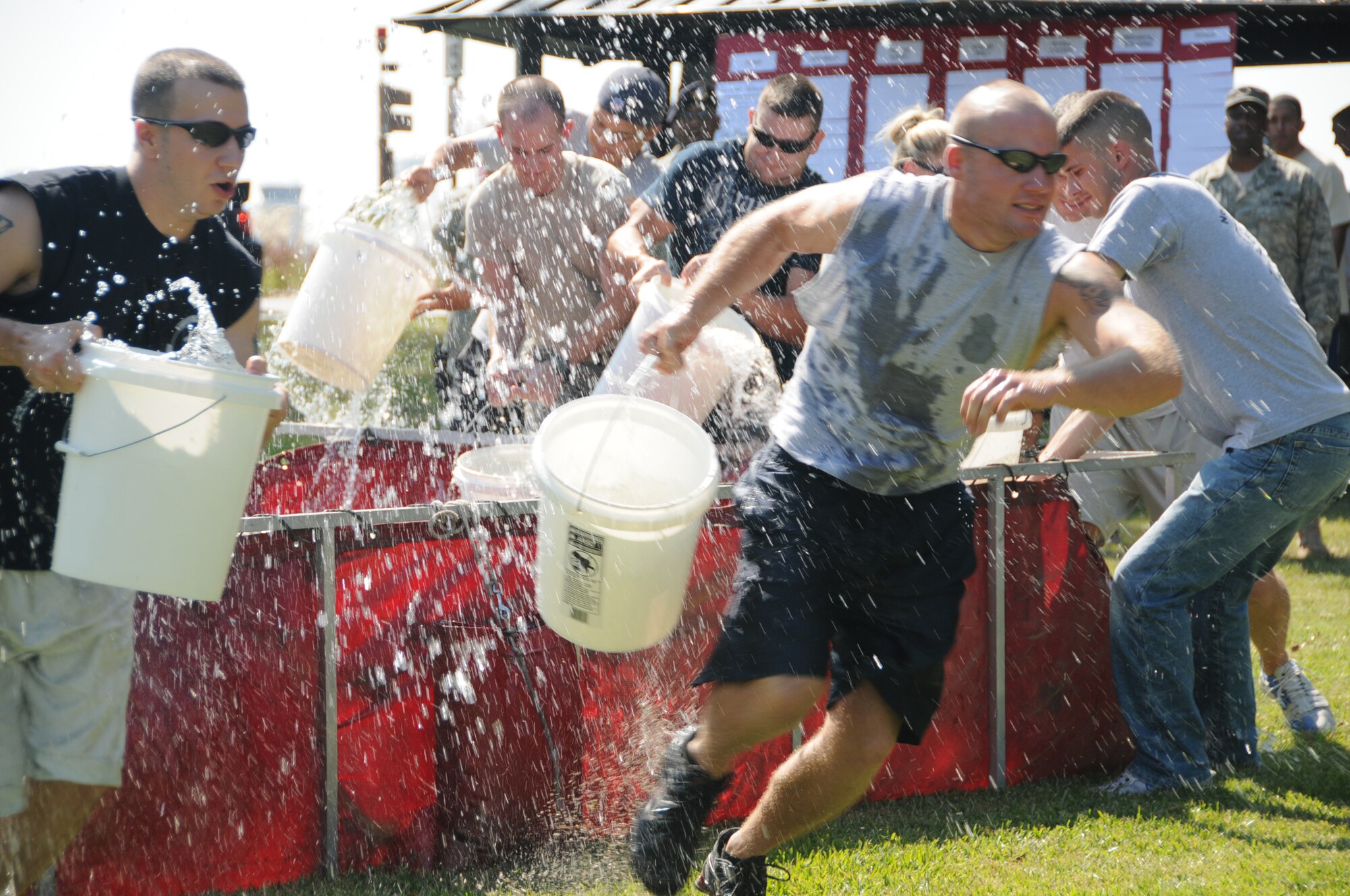 Staff Sgt. Brian Nadler, left, and Airman 1st Class Brian Swithenbank, 81st Security Forces Squadron, race with pails of water for the bucket brigade competition at Friday’s fire muster.  (U.S. Air Force photo by Kemberly Groue)