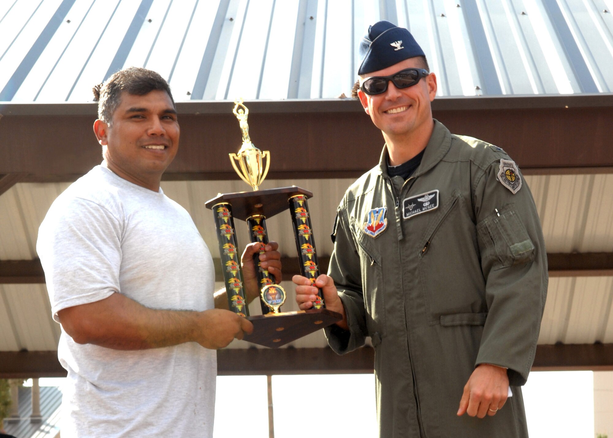 Maj. Anthony Puente, 49th Maintenance Squadron commander, receives first place (Large Squadron award) from Col. Michael McGee, 49th Fighter Wing vice commander, at Holloman Air Force Base, N.M., October 10. Awards were presented to winning squadrons who participated during Sports Day. (U.S. Air Force photo/Airman 1st Class Veronica Salgado)