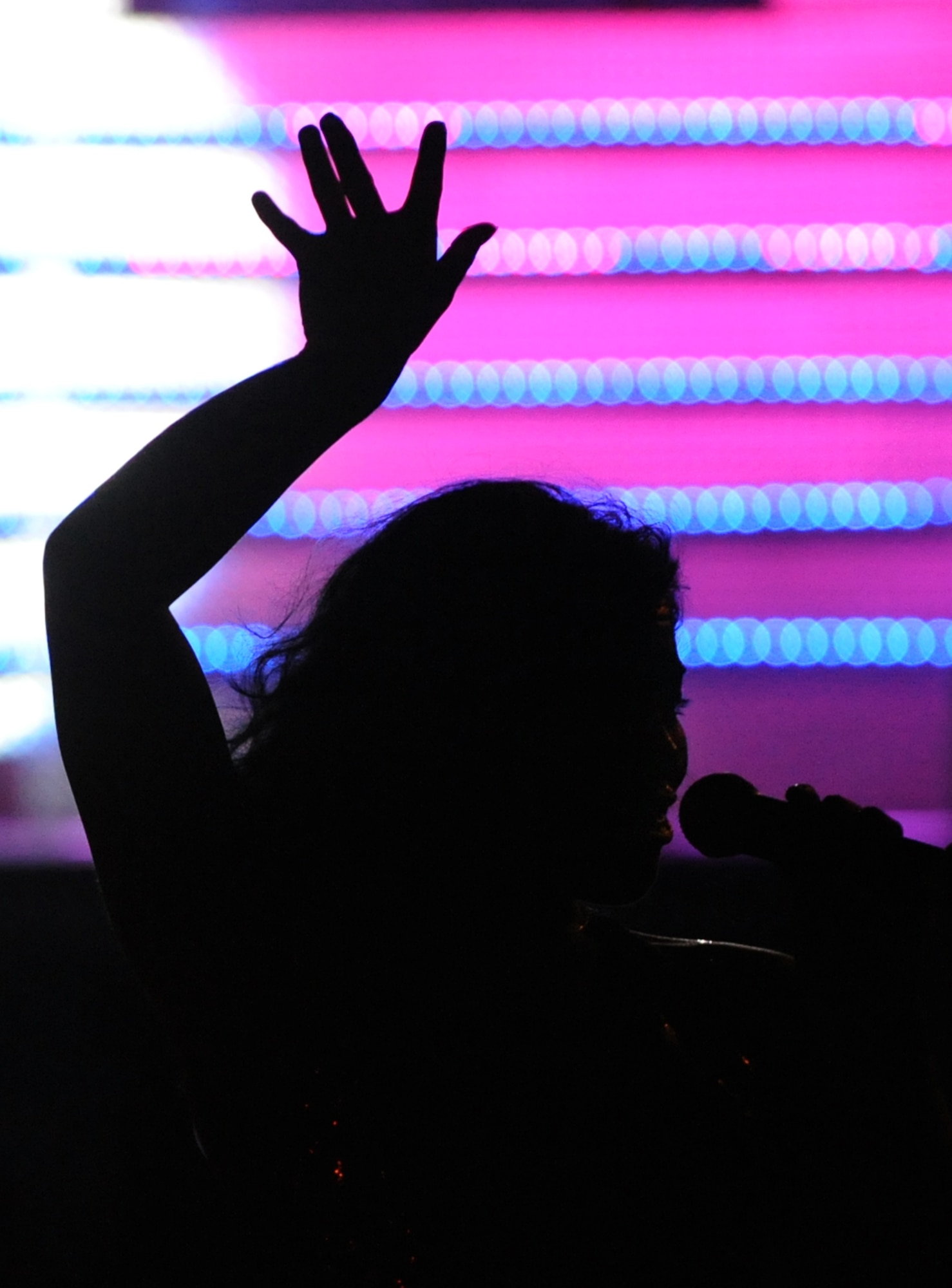 LANGLEY AIR FORCE BASE, Va. -- 2nd Lt. Rhoda Loza, Tops in Blue vocalist, lifted her hand as she leaves the stage during a world tour performance Oct. 12.  Tops in Blue is a widely traveled all active-duty entertainment group, serving the Air Force family with priority to personnel stationed worldwide at remote and deployed locations.  (U.S. Air Force photo/Senior Airman Vernon Young)