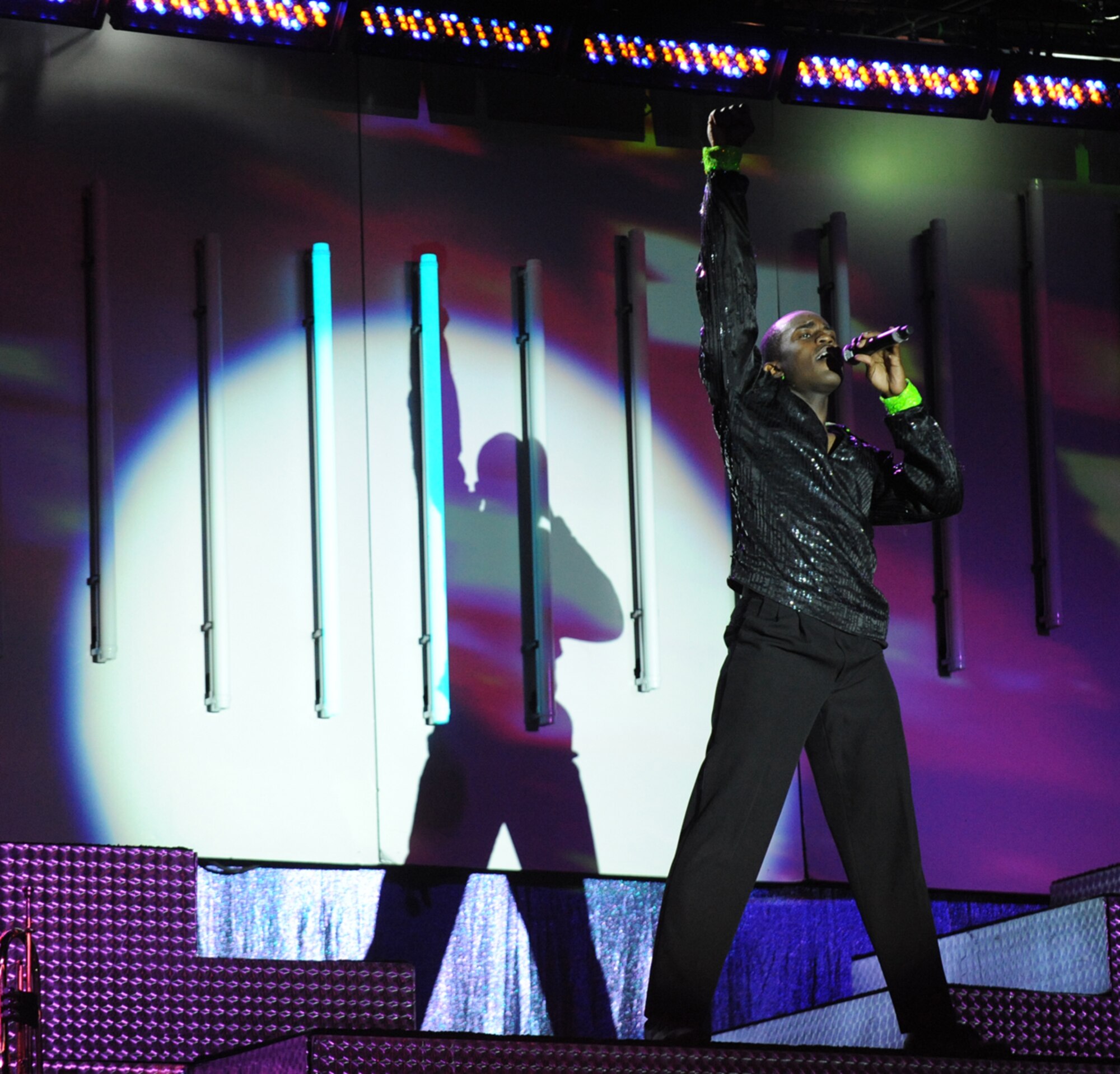 LANGLEY AIR FORCE BASE, Va. -- Airman 1st Class Barry Smith, Tops in Blue vocalist, sings to the crowd during a world tour performance Oct. 12.  Tops in Blue is a widely traveled all active-duty entertainment group, serving the Air Force family with priority to personnel stationed worldwide at remote and deployed locations.  (U.S. Air Force photo/Senior Airman Vernon Young)