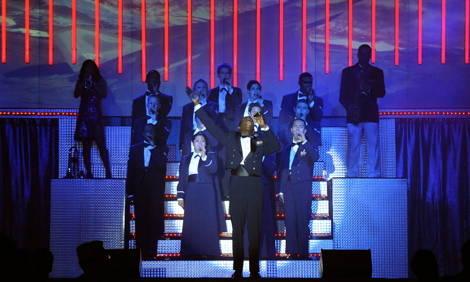 LANGLEY AIR FORCE BASE, Va. -- Airman 1st Class Tommie Crutcher, Tops in Blue vocalist, leads all the vocalists in singing "The U.S. Air Force" song during a world tour Oct. 12.  Tops in Blue is a widely traveled all active-duty entertainment group, serving the Air Force family with priority to personnel stationed worldwide at remote and deployed locations.  (U.S. Air Force photo/Senior Airman Vernon Young)