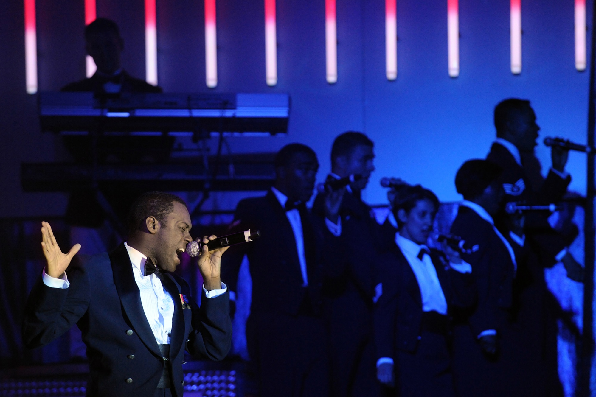 LANGLEY AIR FORCE BASE, Va. -- Airman 1st Class Tommie Crutcher, Tops in Blue vocalist, leads all the vocalists in singing "The U.S. Air Force" song during a world tour Oct. 12.  Tops in Blue is a widely traveled all active-duty entertainment group, serving the Air Force family with priority to personnel stationed worldwide at remote and deployed locations.  (U.S. Air Force photo/Senior Airman Vernon Young)