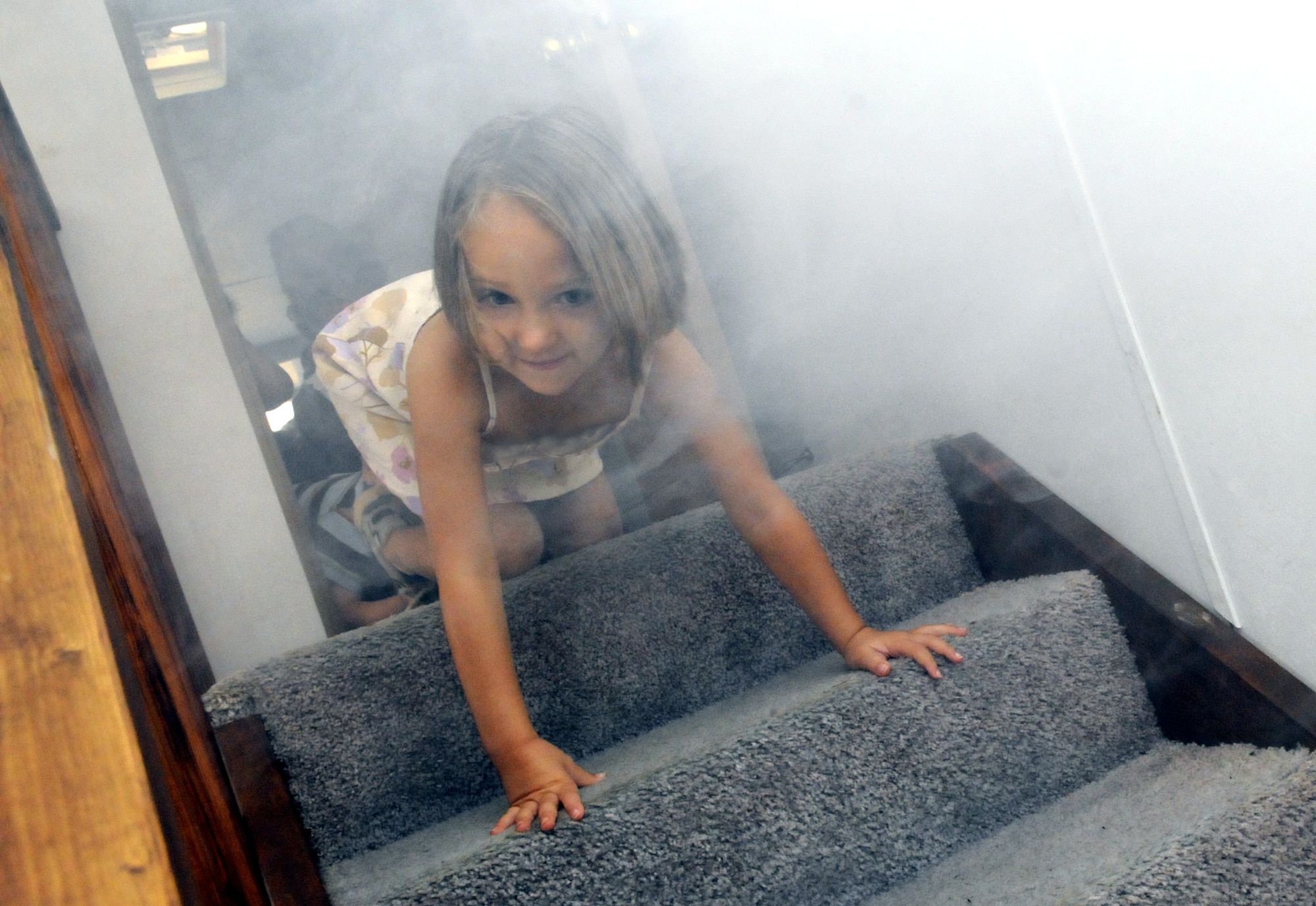 Alyssa Calvert, Robins Elementary Pre-K student, learns to crawl to safety under the simulated fire smoke in the Fire Safety House Oct. 8. U. S. Air Force photo by Sue Sapp