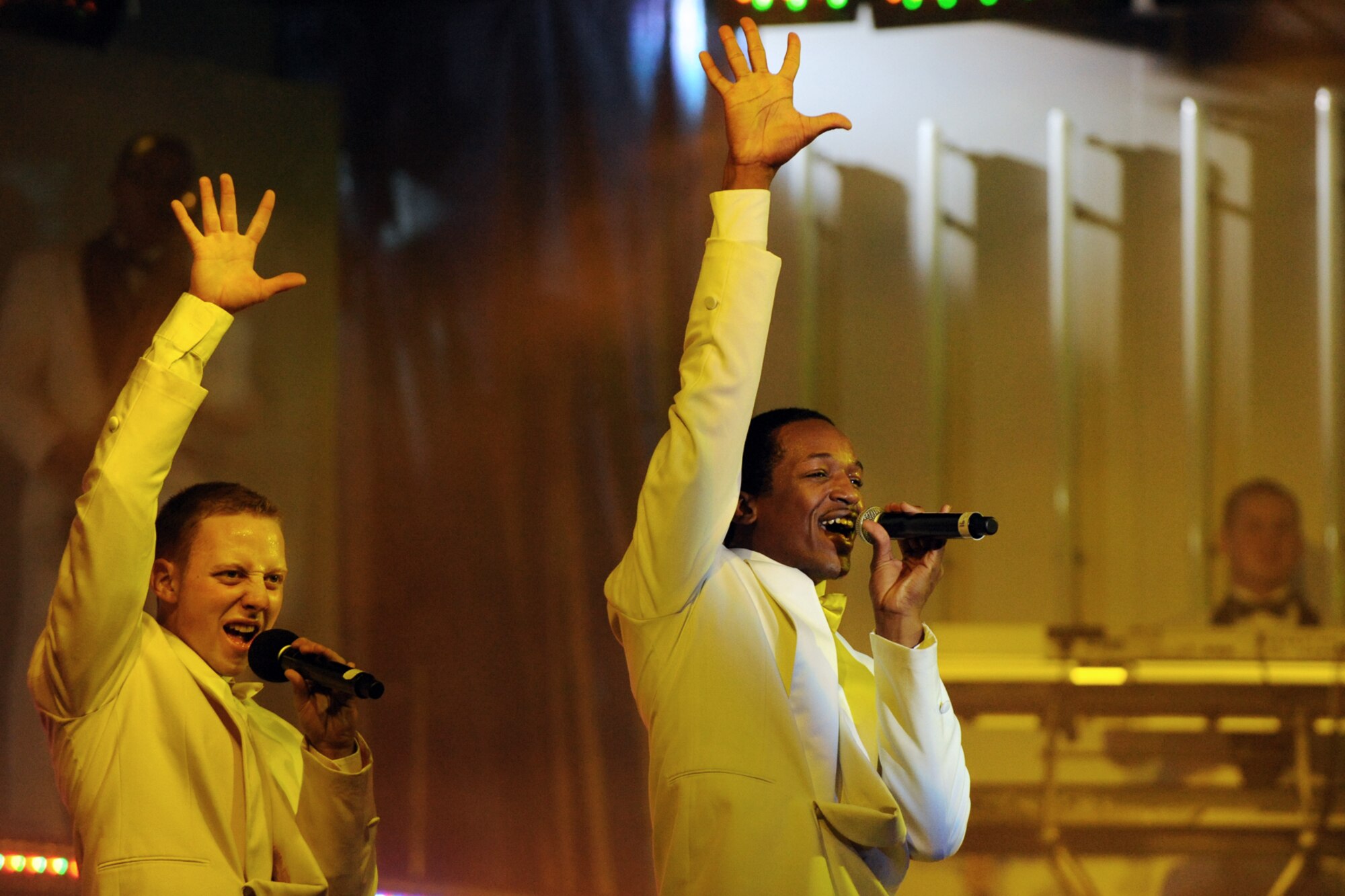 LANGLEY AIR FORCE BASE, Va. -- Airmen 1st Class Quentin Thomas and David Butler, Tops in Blue vocalists, sing to the crowd during a world tour performance.  Tops in Blue is a widely traveled all active-duty entertainment group, serving the Air Force family with priority to personnel stationed worldwide at remote and deployed locations.  (U.S. Air Force photo/Senior Airman Vernon Young)