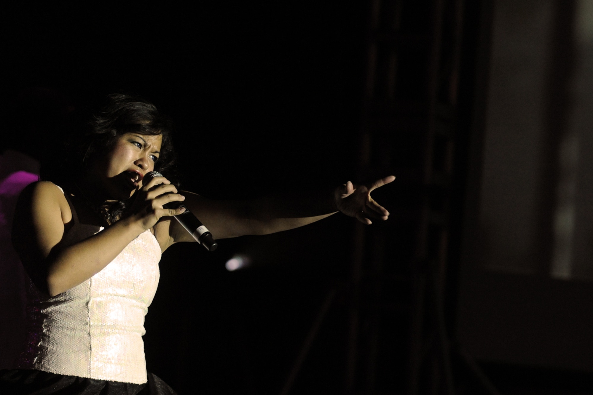 LANGLEY AIR FORCE BASE, Va. -- 2nd Lt. Rhoda Lazo, Tops in Blue vocalist, sings to the crowd during a world tour performance Oct. 12  Tops in Blue is a widely traveled all active-duty entertainment group, serving the Air Force family with priority to personnel stationed worldwide at remote and deployed locations.  (U.S. Air Force photo/Senior Airman Vernon Young)