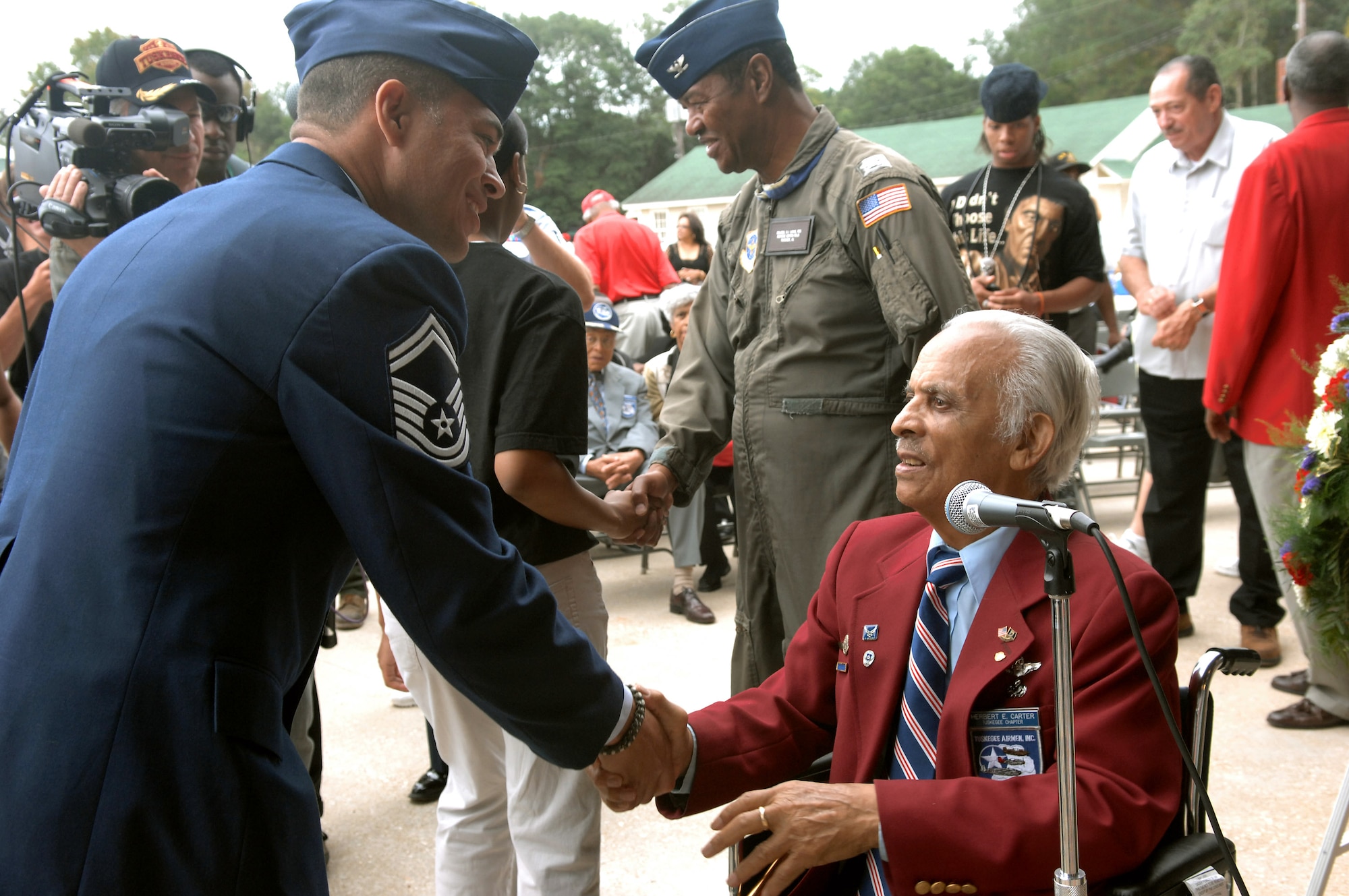 Retired Col. Herbert E. Carter shakes hands with an Airman who he just gave the oath of re-enlistment to Oct. 11 at Moton Field in Tuskegee, Ala. Colonel Carter is one of the original members of the Tuskegee Airmen and was on hand for the opening of the Tuskegee Airmen National Historic Site. Moton Field in the 1940s was the only primary flight training facility for the first African American pilot candidates in the Army Air Corps, these pilots are known as the Tuskegee Airmen. (U.S. Air Force photo/Staff Sgt. Christine Jones)
