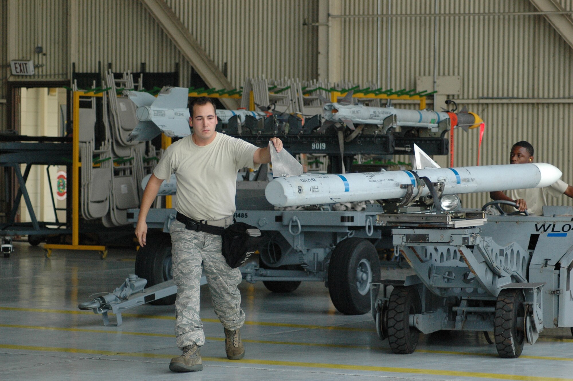 Staff Sgt. David Rodriguez and Airman 1st Class Erik Lee, 58th AMU, transport an AIM-120 from the MHU-141 trailer to the F-15 to be loaded in a race against the clock with the 60th AMU during an Oct. 10 quarterly weapons load competition. While they finished the load faster, the 60th AMU took top honors. (U.S. Air Force Photo/Chrissy Cuttita)