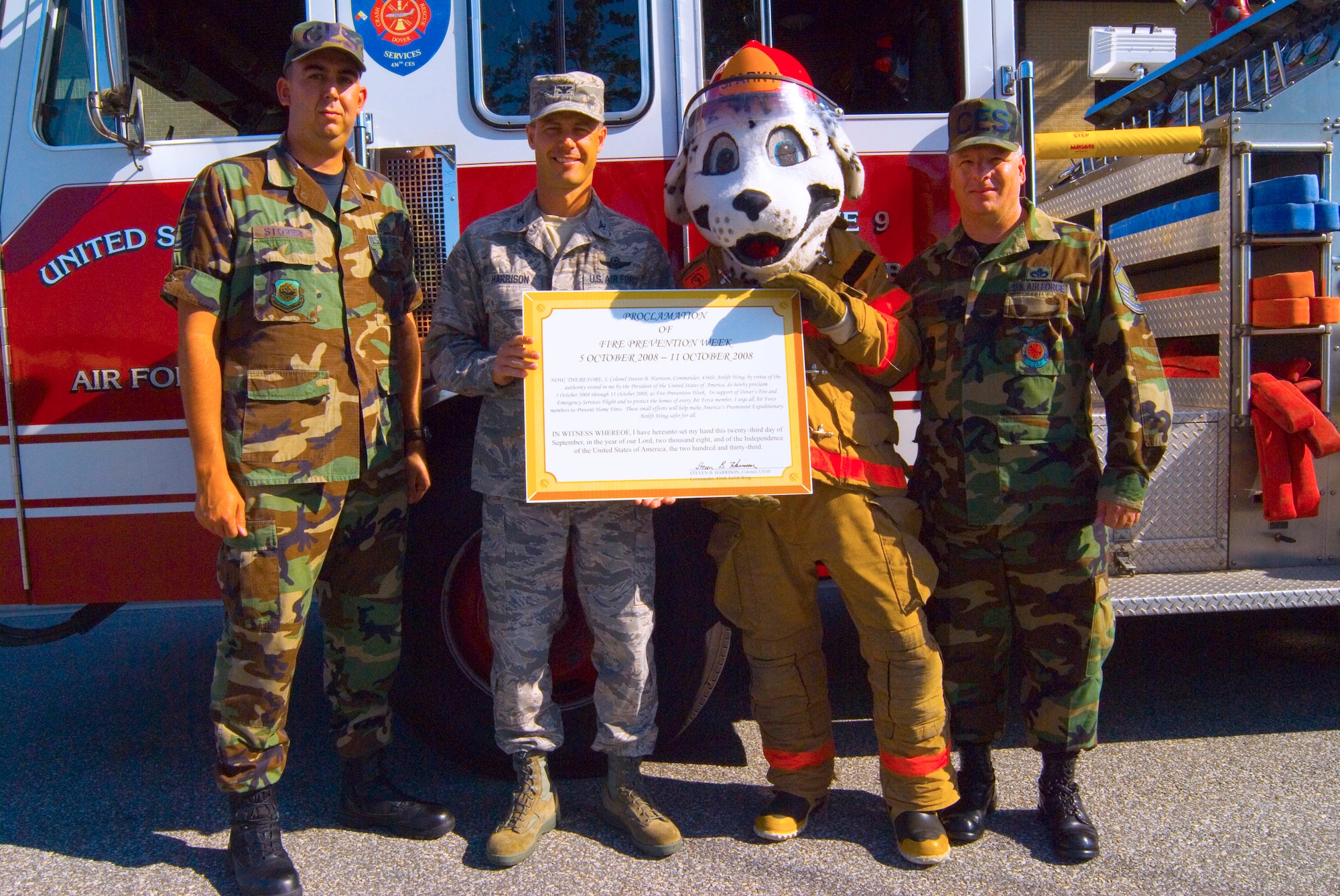 (Left to right) Tech. Sgt. Steven Stover, 436th Civil Engineer Squadron, Col. Steven Harrison, 436th Airlift Wing commander, Sparky the Fire Dog and Master Sgt. Timothy Brown, 436th CES fire chief, present the signed proclamation for Fire Prevention Week Sept. 23. Fire prevention week featured a parade through base housing and an open house at the Fire Station. (U.S. Air Force photo/Senior Airman James Bolinger)