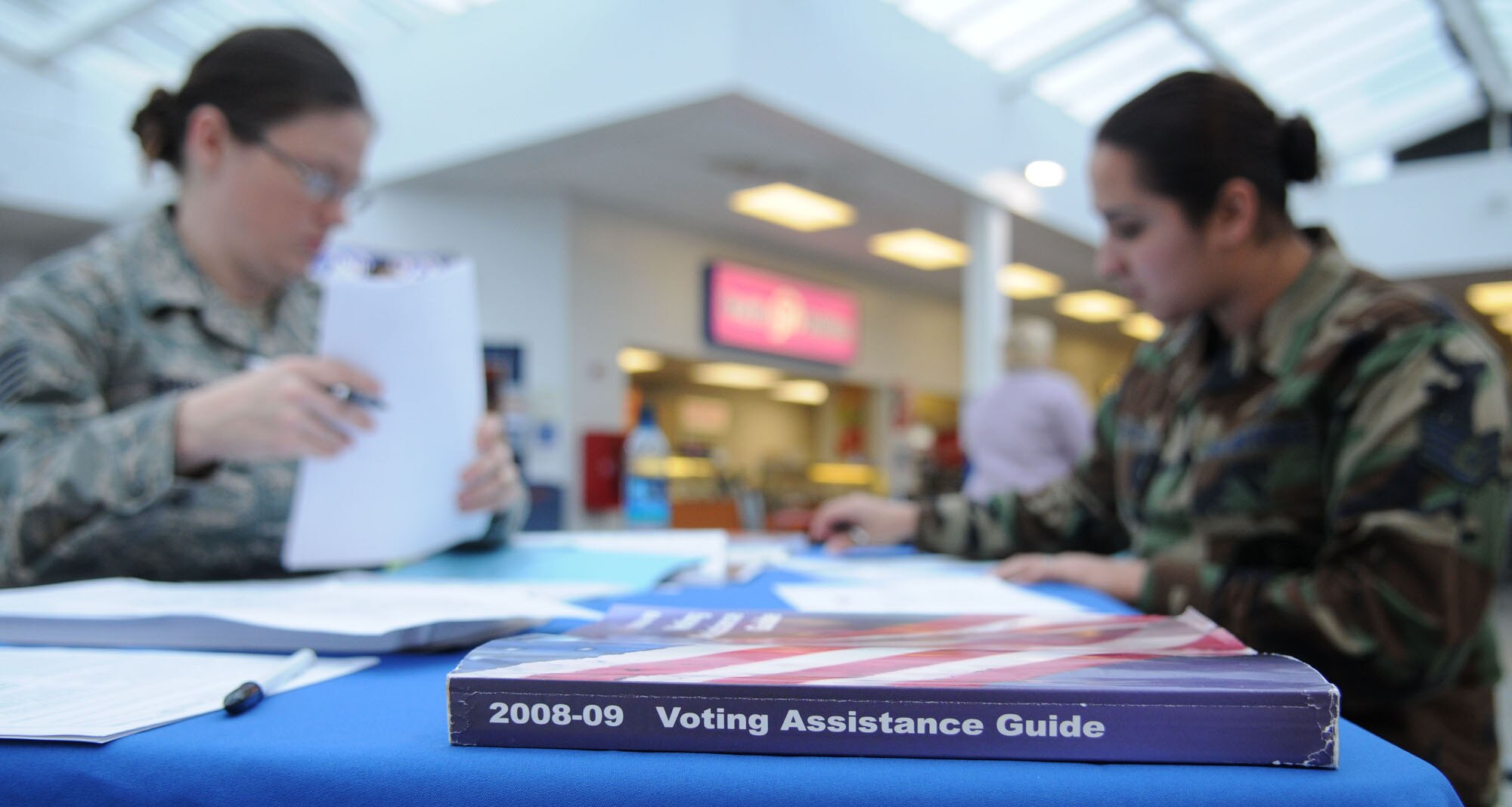 RAF MILDENHALL, England -- Tech. Sgt. Sarah Shuss, a propulsion craftsman from the 373rd Training Squadron Detachment 19, reviews the absentee voting procedures with Staff Sgt. Barbara Johnson, a personnel craftsman from the 100th Force Support Squadron at the BXtra Oct. 15, 2008. This week is the deadline for overseas absentee voting ballots to be submitted. (U.S. Air Force photo by Staff Sgt. Jerry Fleshman)