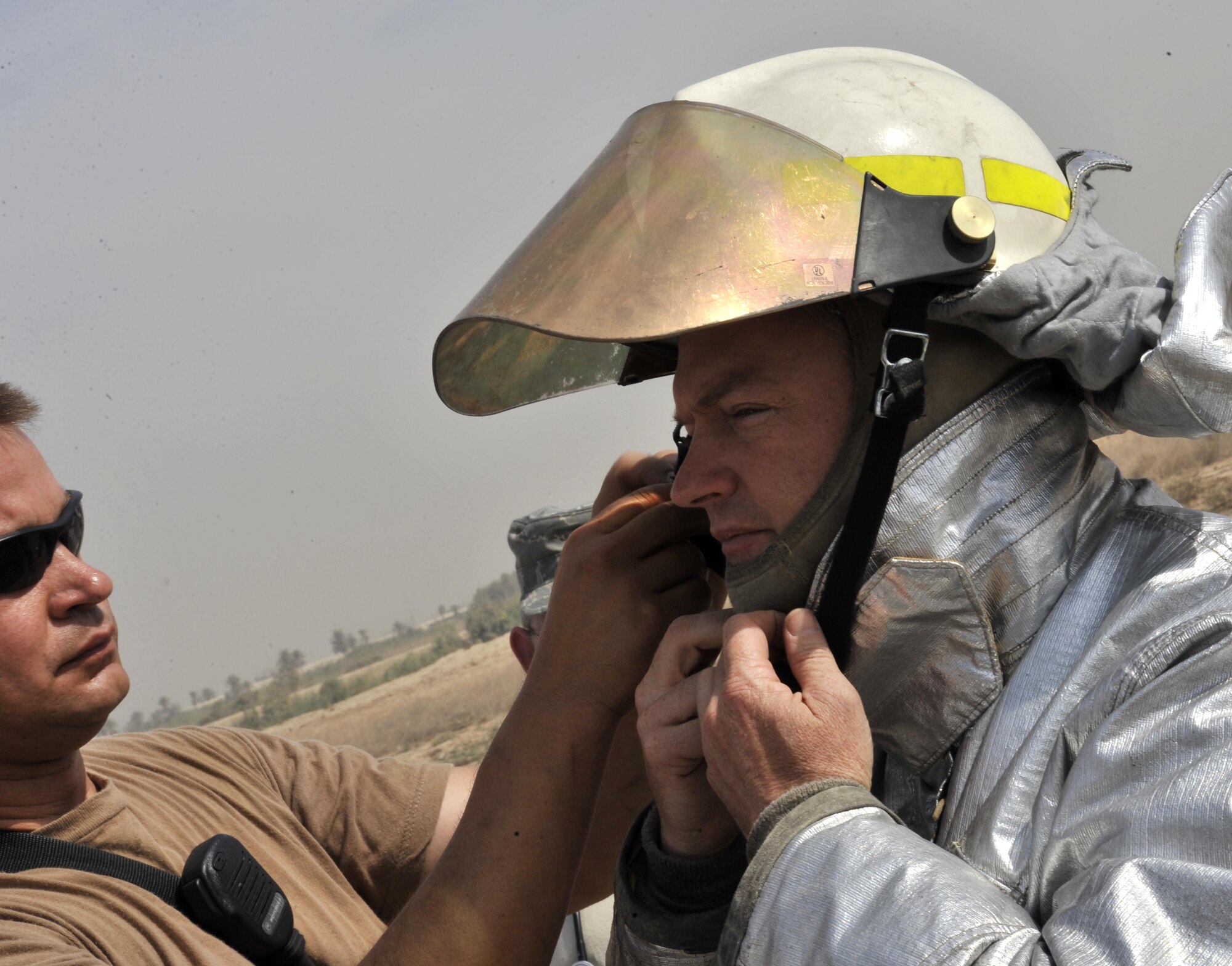 10/15/2008 ? SATHER AIR BASE, Iraq ? Tech. Sgt. Scott Kaufman (left) teaches Col. David Pavey how to properly don firefighting equipment during a live burn exercise at Sather Air Base. Colonel Pavey is the commander of the 447th Air Expeditionary Group, and is deployed from his position as the commander of the 446th Operations Group, McChord Air Force Base Wash. Sergeant Kaufman is a North Dakota Air National Guard firefighter deployed to the 447th Expeditionary Civil Engineer Squadron from the 119th Wing in Fargo where he is a full-time state firefighter. The 447th AEG is made up of active duty, Air Force Reserve and Air National Guard Airmen who are responsible for airfield operations on the west side of Baghdad International Airport, one of the busiest aerial hubs in Iraq. (U.S. Air Force photo by Master Sgt. Brian Davidson)