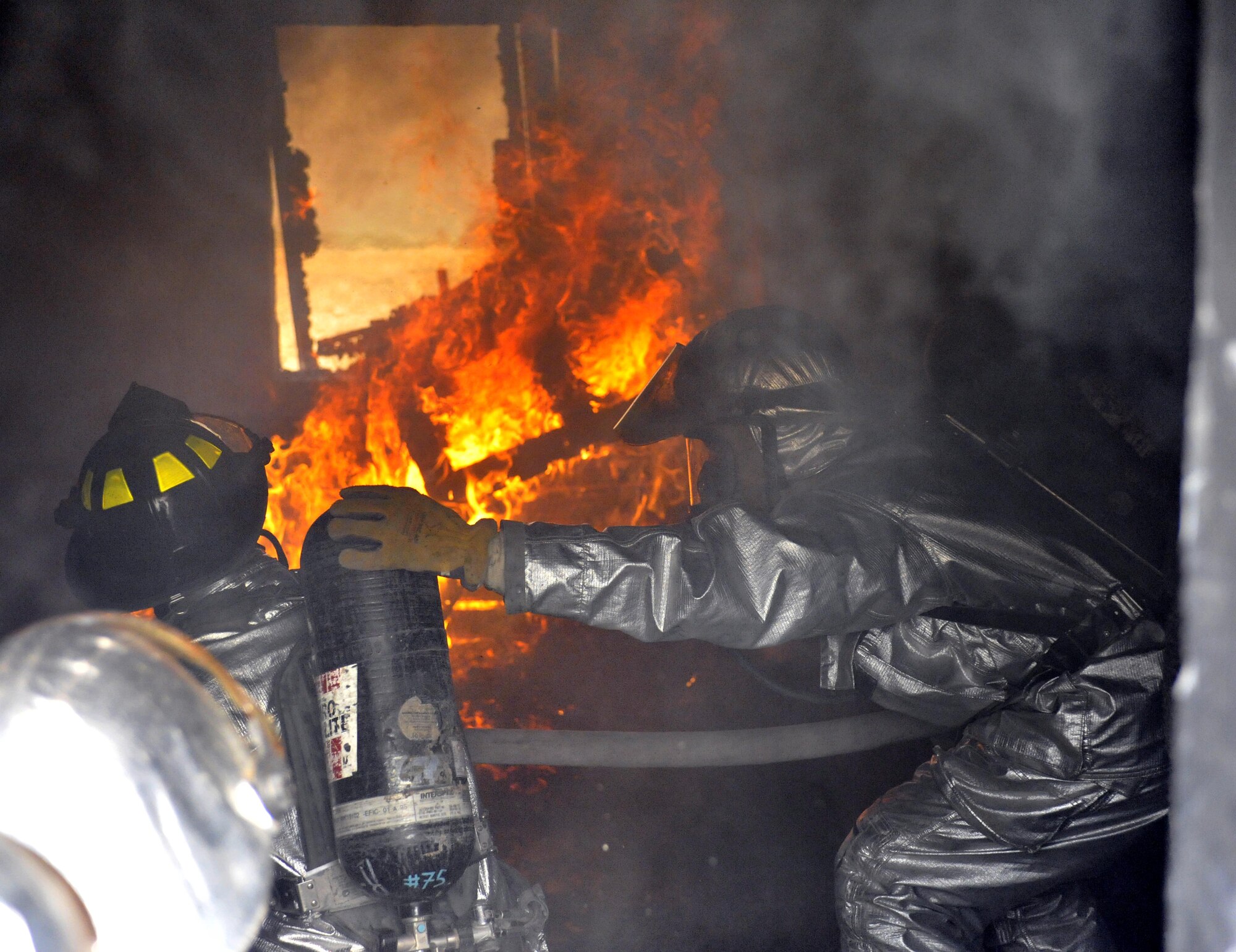 10/15/2008 ? SATHER AIR BASE, Iraq - Firefighters from the 447th Expeditionary Civil Engineer Squadron at Sather Air Base move in to extinguish a structure fire during a live burn exercise. The unit is made up of Air National Guard Airmen who are responsible for fire protection and rescue operations for the base and airfield on the west side of Baghdad International Airport, one of the busiest aerial hubs in Iraq. (U.S. Air Force photo by Master Sgt. Brian Davidson)
