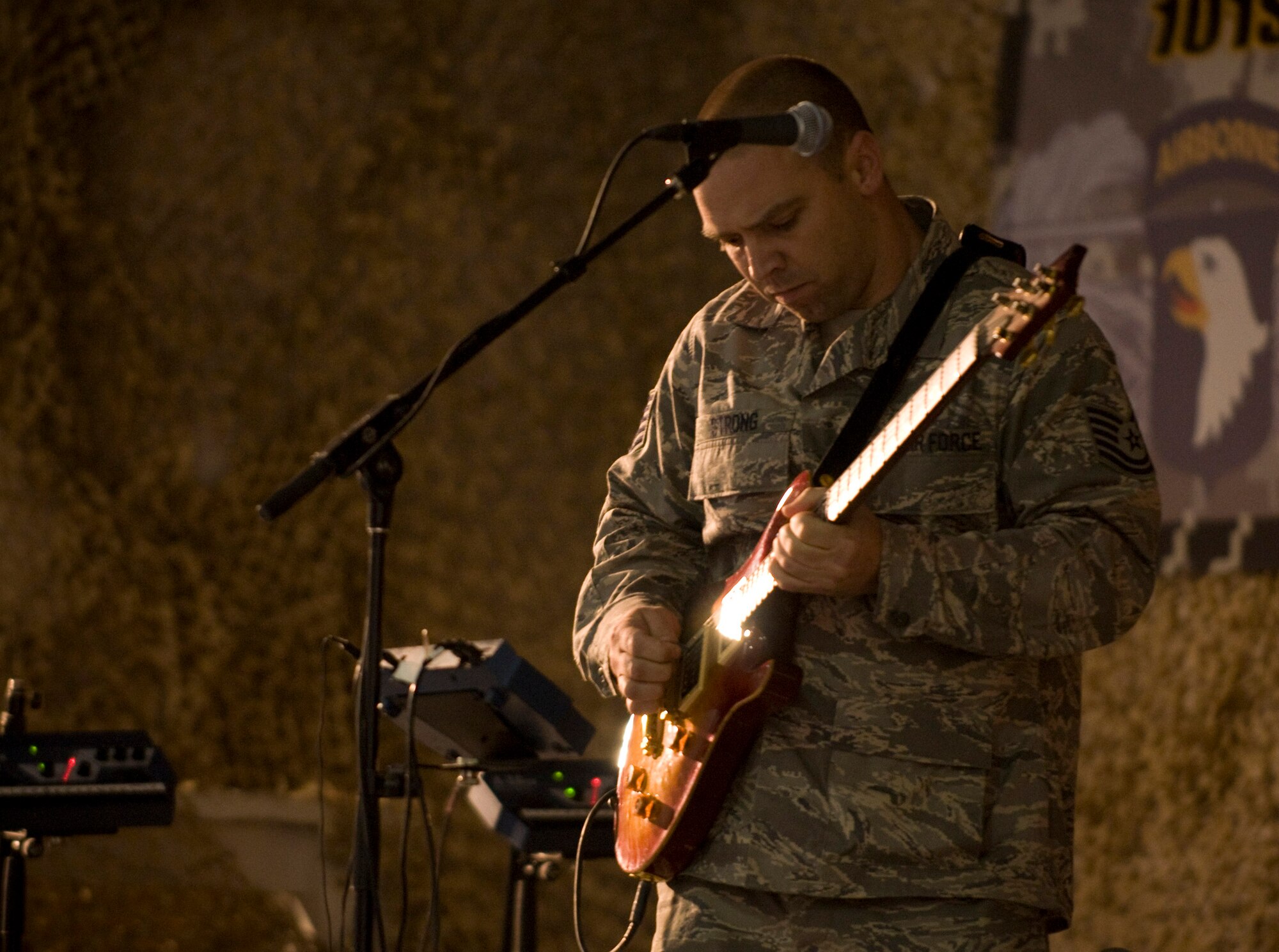 BAGRAM AIR FIELD, Afghanistan -- Tech. Sgt. Samuel Strong plays lead guitar for "Sweet Home Alabama" with U.S. Air Forces Central band "Yuma" during the band's feature performance here Oct. 10. Sergeant Strong is a refueler with the 455th Expeditionary Logistics Readiness Squadron deployed from Charleston Air Force Base, S.C., and hails from Norton, Va. (U.S. Air Force photo by Staff Sgt. Samuel Morse)