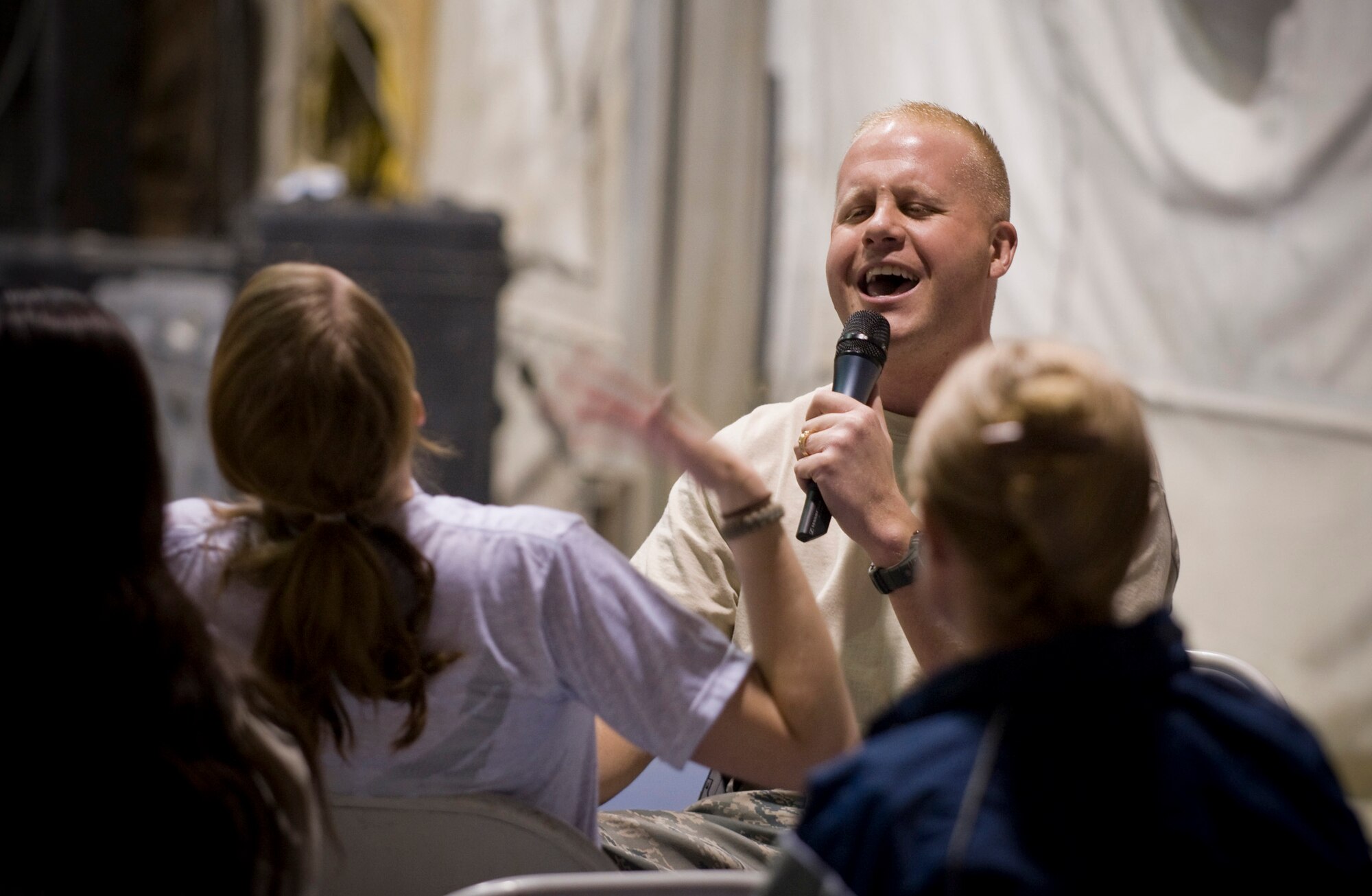 BAGRAM AIR FIELD, Afghanistan -- Master Sgt. Ryan Carson, lead male vocalist for U.S. Air Forces Central band "Yuma," sings to Senior Airman Brianna Riedel, 455th Expeditionary Operations Support Squadron Weather Flight, during the band's feature performance here Oct. 10. The Band played a two-hour show encompassing genres ranging from country to hard rock. Airman Riedel is deployed from the 18th Operations Support Squadron, Kadena Air Base, Japan, and hails from Bettendorf, Iowa. (U.S. Air Force photo by Staff Sgt. Samuel Morse)