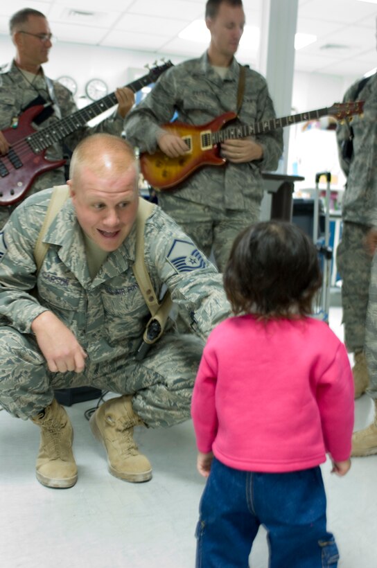BAGRAM AIR FIELD, Afghanistan -- Master Sgt. Ryan Carson, lead male vocalist for U.S. Air Forces Central band "Yuma," sings to an Afghan child here Oct. 7. The band performed at the Task Force Medical to boost morale and promote their feature show later that week. (U.S. Air Force photo by Capt. Thomas Wenz/Released)
