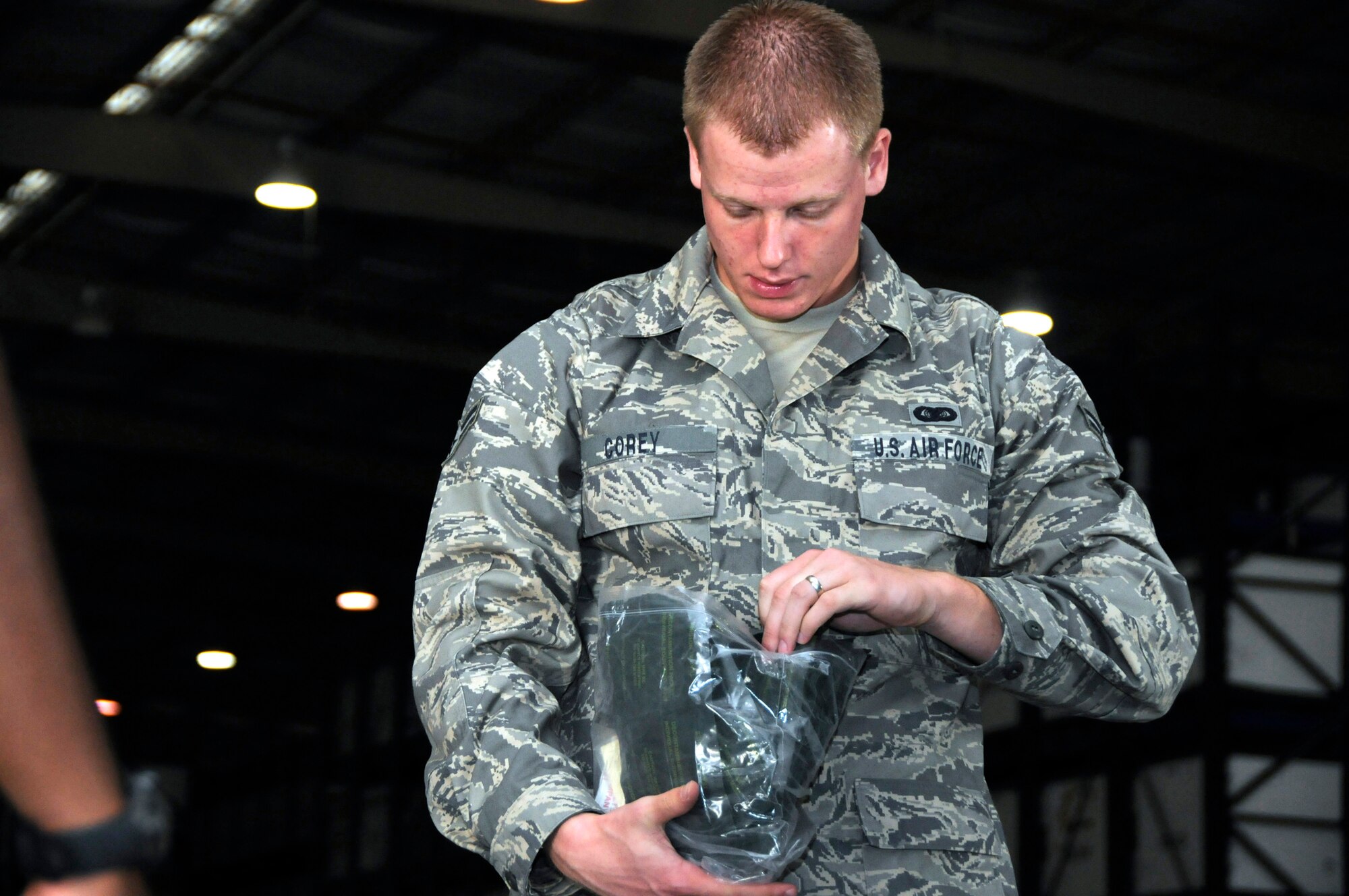 Airman 1st Class John Corey, commander's executive aide assigned to the 379th Expeditionary Operations Group, inventories the number of large decontamination kits inside his chemical bag or C-bag, October 15, 2008, at an undisclosed air base in Southwest Asia.  C-bags were issued to all base personnel as part of a base defense exercise.  Airman Corey, a native of Jacksonville, Fla., is deployed from Keesler Air Force Base, Miss., in support of Operations Iraqi and Enduring Freedom and Joint Task Force-Horn of Africa.  (U.S. Air Force photo by Tech. Sgt. Michael Boquette/Released)