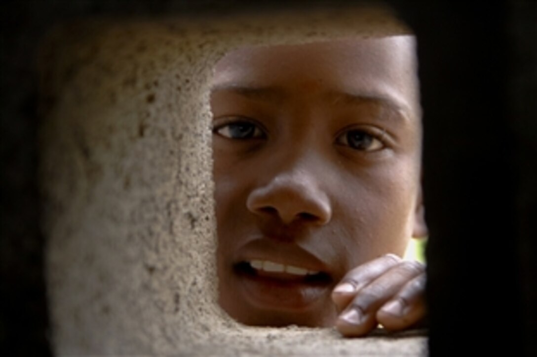A young Dominican boy peers though a window at Bayaguana Sports Complex as crew members embarked aboard the amphibious assault ship USS Kearsarge provide medical and dental aid to local citizens supporting Continuing Promise 2008, Bayaguana, Domincan Republic, Oct. 15, 2008.