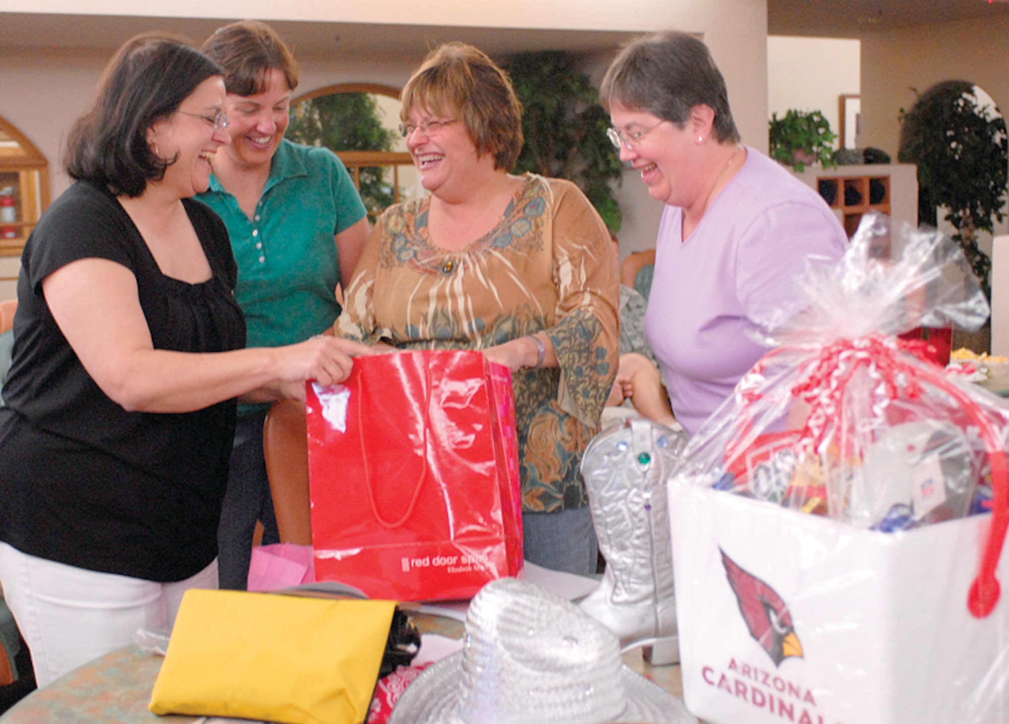 Luke Officers' Spouses Club members, Carol Ann Stentz, Lisanne Migyanko, Rhonda Chozinski and Liz Plaumann, go through some of the items to be auctioned in the club's Denim and Diamonds Chairty Auction at 6 p.m. today at the Desert Star Club. The LOSC does a variety of fundraising and social events throughout the year. (U.S. Air Force photo/Deborah Silliman Wolfe.)