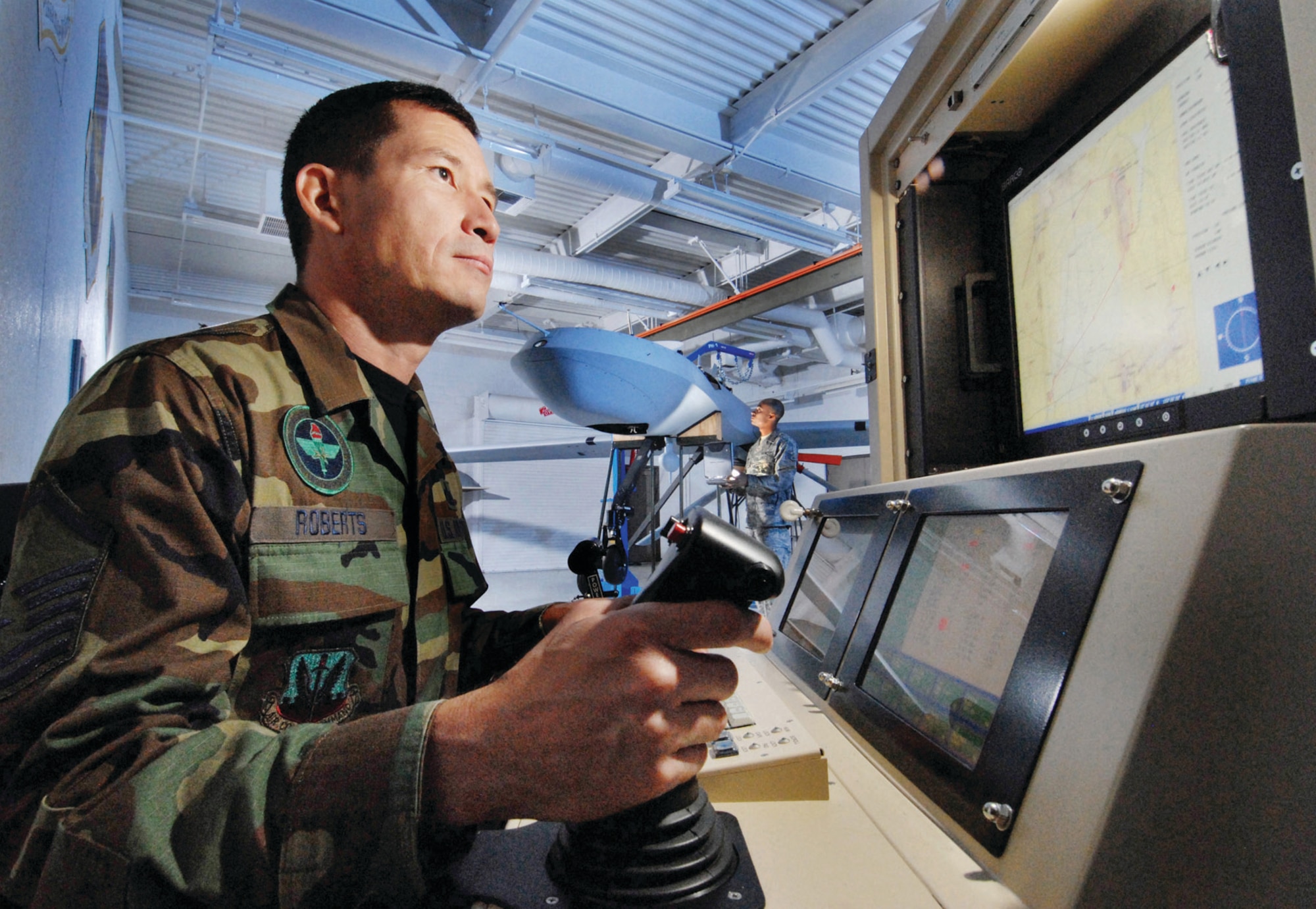 Master Sgt. Fred Roberts, left, an instructor assigned to Field Training Detachment (FTD), 163rd Maintenance Group, California Air National Guard, uses a Single Base Station maintenance interface station to check an MQ-1 Predator unmanned aerial vehicle while Staff Sgt. Alex Bush, back, a crew chief assigned with the 163d Reconnaissance Wing, visually inspects the MQ-1 at March Air Reserve Base, Calif., Oct. 15. Members of the FTD train active duty, Reserve and Air National Guard personnel on Predator maintenance operations. (U.S. Air Force photo by Val Gempis)