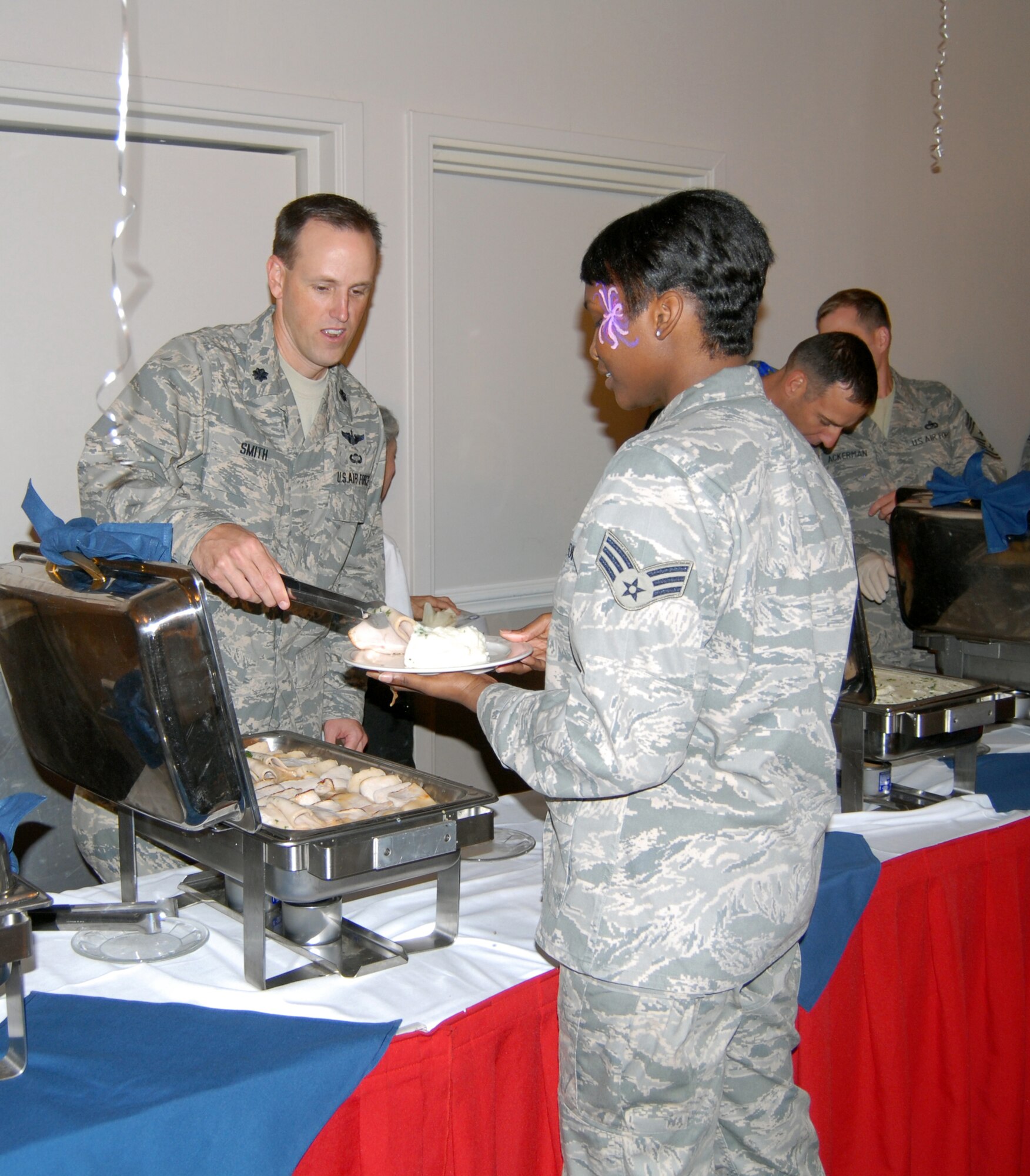 Senior Airman Lisa Williams, 43rd Security Forces Squadron, is served a slice of grilled turkey by Lt. Col. Lee Smith, 2nd Airlift Squadron Commander during the Airman's Appreciation Dinner at the Pope Club Oct. 7. (U.S. Air Force Photo by Emily Smith)