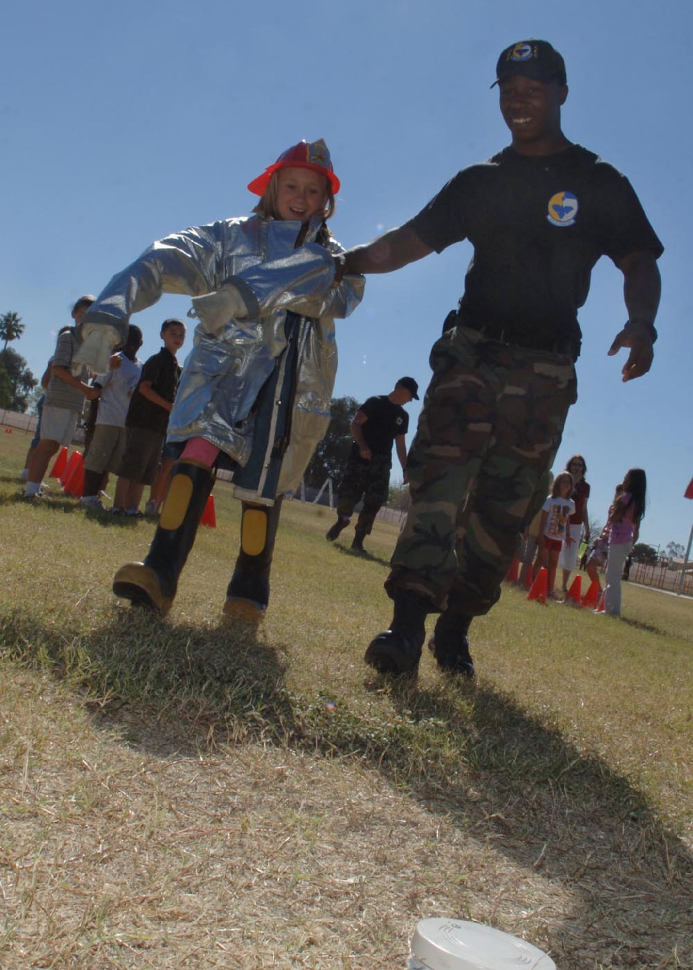 Airman 1st Class Jon Wilson, 355th Civil Engineer Squadron, assists Paige, daughter of Sarah and Capt. Dennis Hargis, in reaching a smoke detector Oct. 8 at Borman Elementary School on Davis-Monthan Air Force Base, as part of Fire Prevention week. Photo by: Christina D. Kinsey
