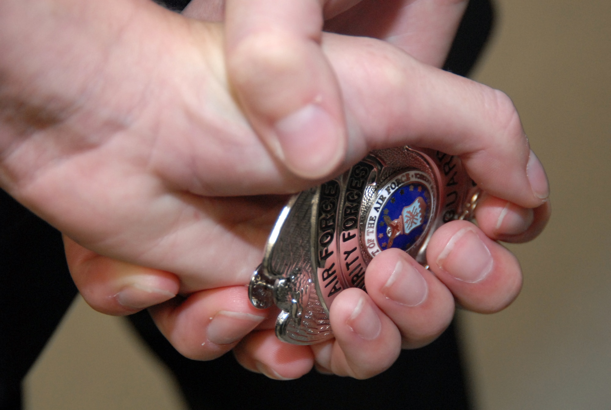 A 95th Security Forces civilian security force holds her badge during a ceremony at the 95th SFS headquarters Oct. 9. Twenty-three civilians received their badges from Maj. Steven Heffington, 95th SFS commander. (Air Force photo by Senior Airman Julius Delos Reyes)