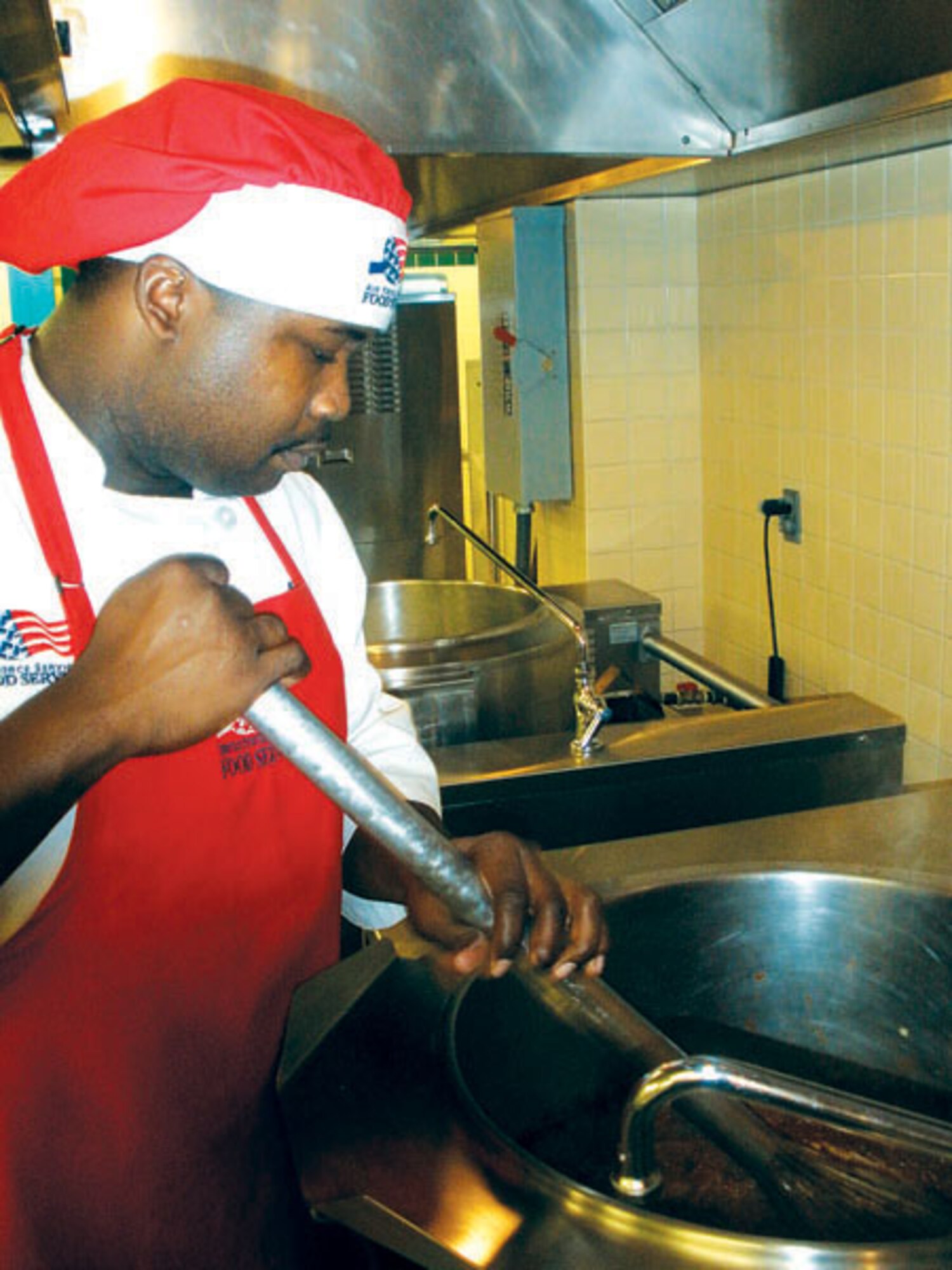 Staff Sgt. Adrian Banks, 90th Force Support Squadron, prepares food at the Chadwell dining facility Oct. 7. A food service excellence  inspection team visited the facility this week to evaluate the dining facility’s staff on five key elements of excellence: kitchen operations; serving and dining operations; training, personnel and readiness; sanitation and repair maintenance; and management. If the staff does well during the command-level inspection, they will earn a Hennessey award and compete at Air Force level. The results are posted in January. (Photo by Col. Kathleen Cook.)