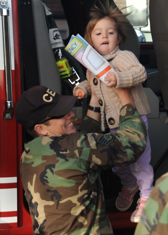 VANDENBERG AIR FORCE BASE, Calif.-- Staff Sgt. Jeremy Camacho shows a little girl the inside of the fire truck during the Fire Fighter Parade here Oct.10.
 (U.S. Air Force photo/Airman 1st Class Andrew Satran)
