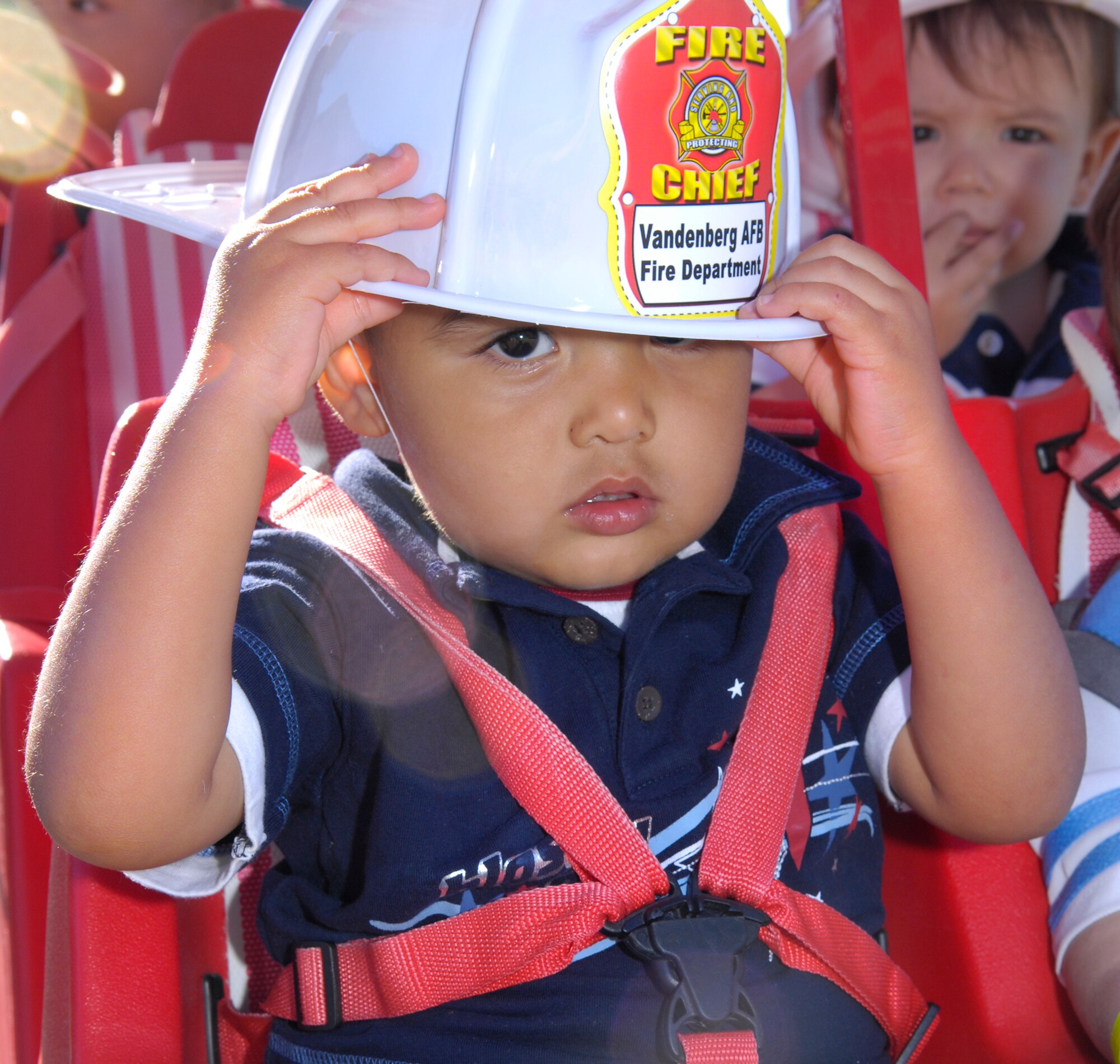 VANDENBERG AIR FORCEBASE, Calif-  A child from the Child Development Center adjusts his fireman hat on his head that was given to him by a firefighter, here Oct. 7. The Vandenberg Hotshots stopped at the CDC as part of Fire Prevention Week.   (U.S. Air Force Photo/ by Airman 1st Class Andrew Lee)