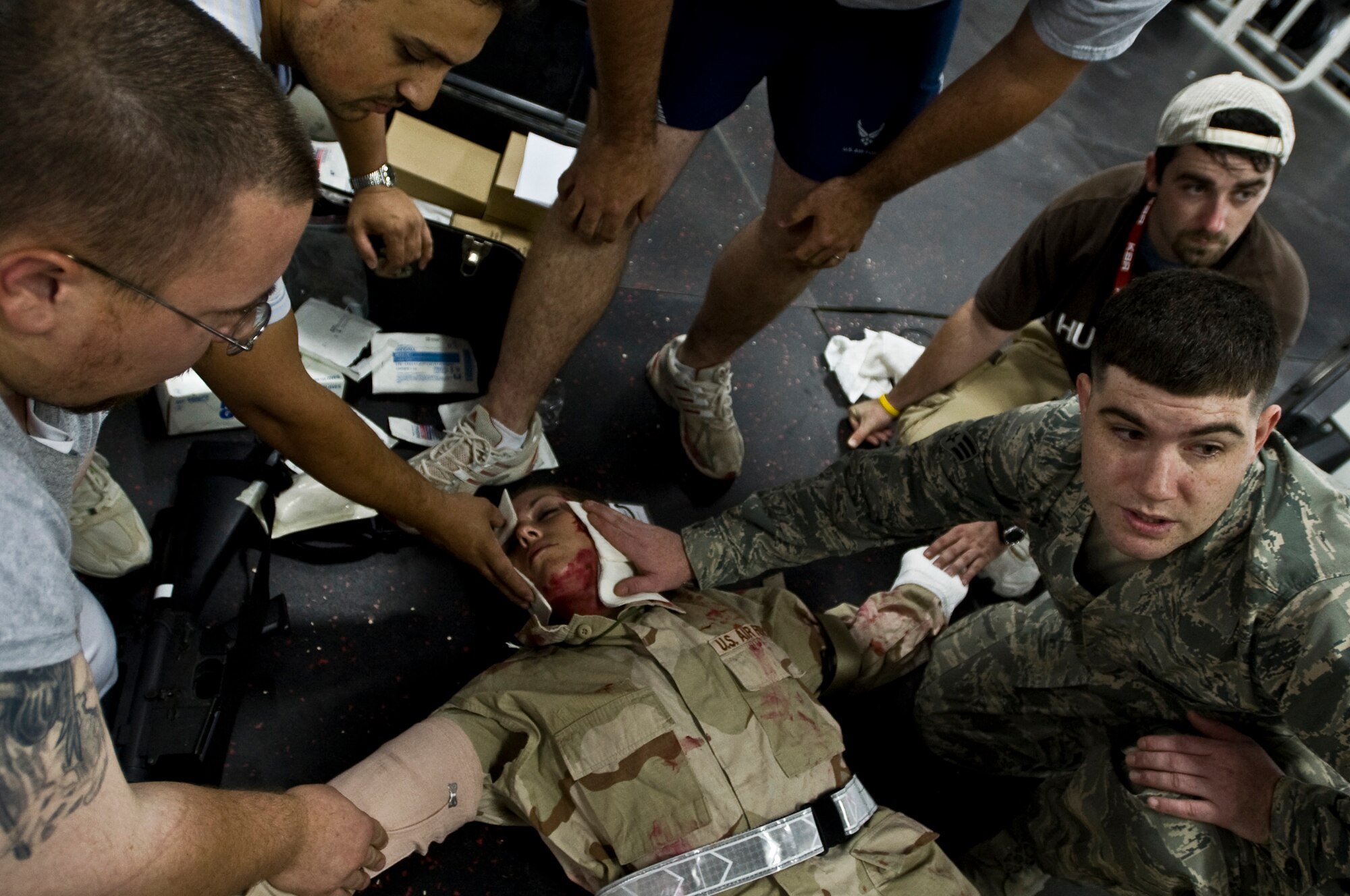 ALI BASE, Iraq -- Airmen and civilian contract employees use self aid buddy care on a victim of an indirect fire attack Oct. 15, 2008. An indirect fire exercise was held here to test the response of nonmilitary and military members. It also tested skills like self aid buddy care and procedures for identifying UXOs. (U.S. Air Force photo/Senior Airman Christopher Griffin)