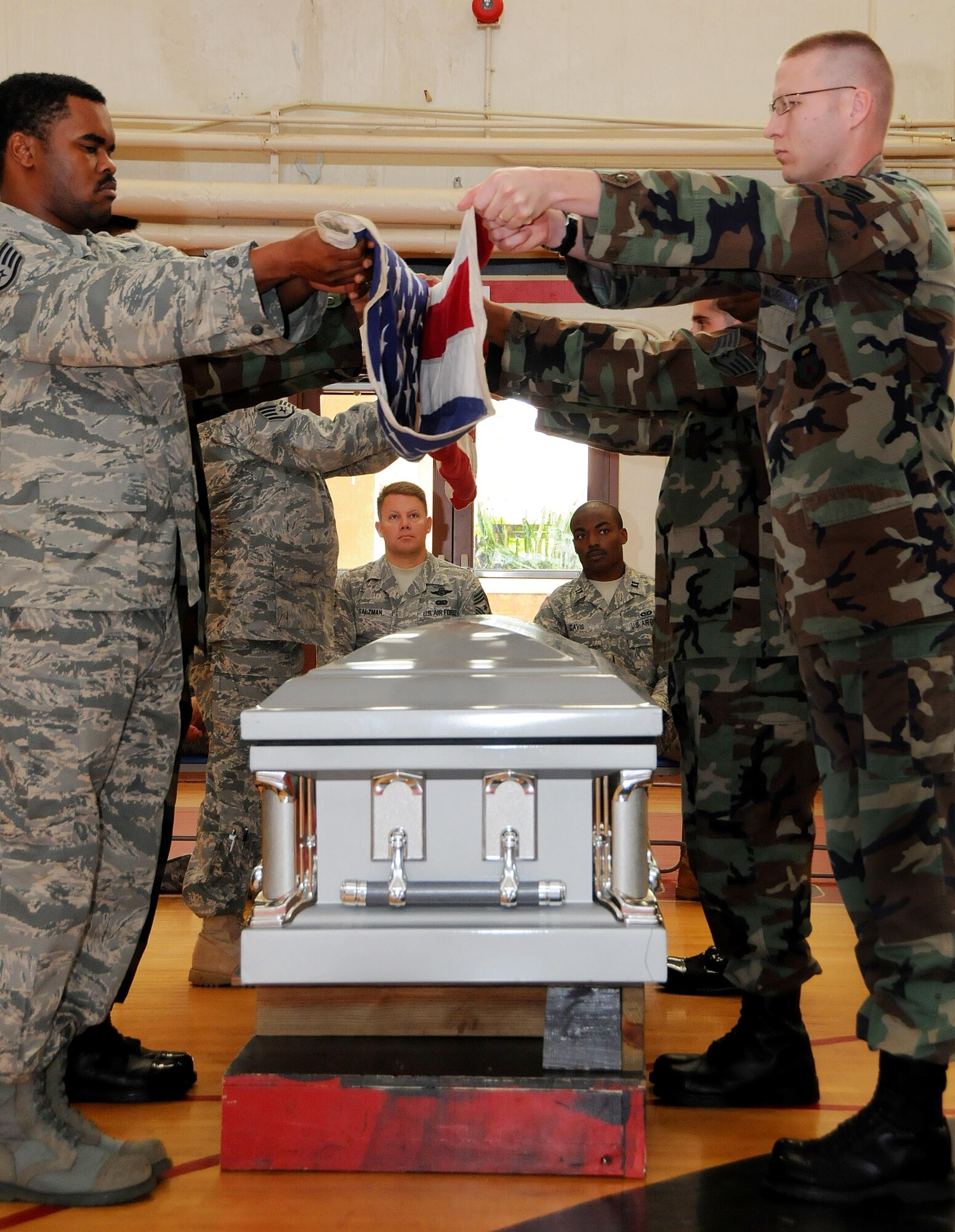 ANDERSEN AIR FORCE BASE, Guam - Thirteenth Air Force Command Chief Master Sgt. Todd Salzman and Capt. Khary Davis, 554th RED HORSE Squadron, watch as Team Andersen Honor Guard Airmen perform a mock funeral here Oct. 17. The Honor Guard’s primary mission is to provide final military honors to fallen military members.  (U.S. Air Force photo by Airman 1st Class Courtney Witt)