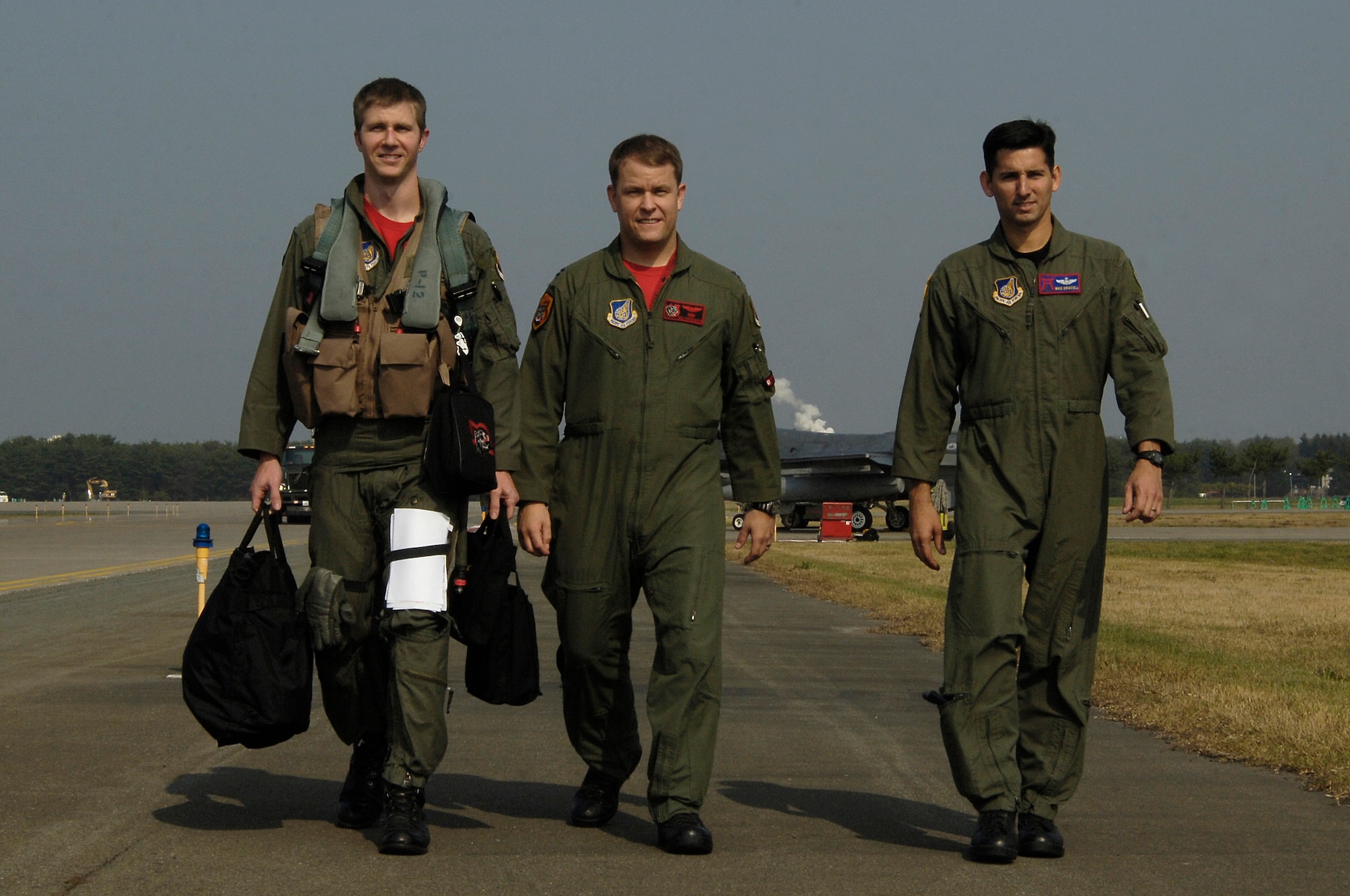 MISAWA AIR BASE, Japan -- Capt. Jeffrey Schneider, Capt. Eric Freienmuth, and Capt. Michael Driscoll, pilots from the 13th Fighter Squadron walk off the flight line Oct 16, 2008. They won the award for best fighter squadron and wing during a "virtual" air combat exercise flown from simulator cockpits around the globe. (U.S. Air Force photo by Staff Sgt Araceli Alarcon)