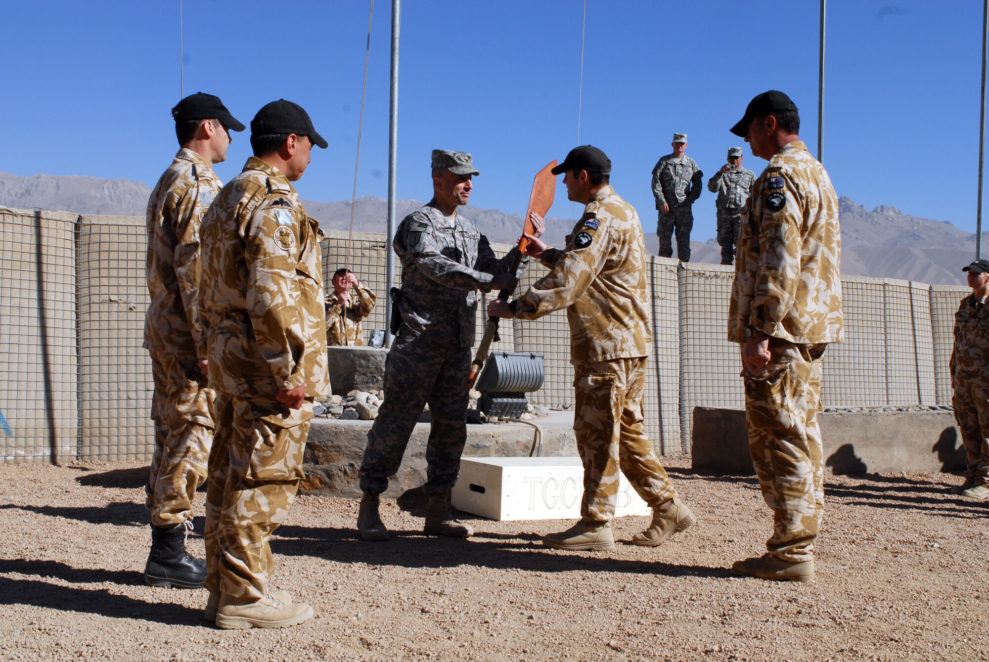 Outgoing New Zealand/Bamyan Provincial Reconstruction Team commander Col. Daryl Tracy passes the ceremonial paddle to Combined Joint Task Force 101's Task Force Warrior Commander Col. Scott Spellmon during the PRT change of command in Bamyan. TF Warrior serves as the higher headquarters for the Bamyan/New Zealand PRT. New Zealand Defence Force TG Crib 12 has completed six months in Bamyan and has been succeeded by TG Crib 13.