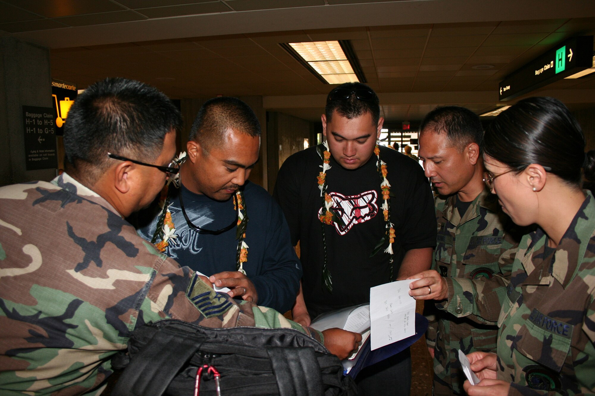 Tech Sgt. Sean Concepcion and Senior Airman Devin Caringer of the 624th Regional Support Group, are welcomed home by Master Sgt. Abner Ganigan, Lt. Col. Randall Honke, and Tech Sgt. Kristy Turner at Honolulu International Airport in Honolulu after a 4-month deployment to Balad Air Base, Iraq.  All are members of the 48th Aerial Port Squadron based out of Hickam Air Force Base, Hawaii.  