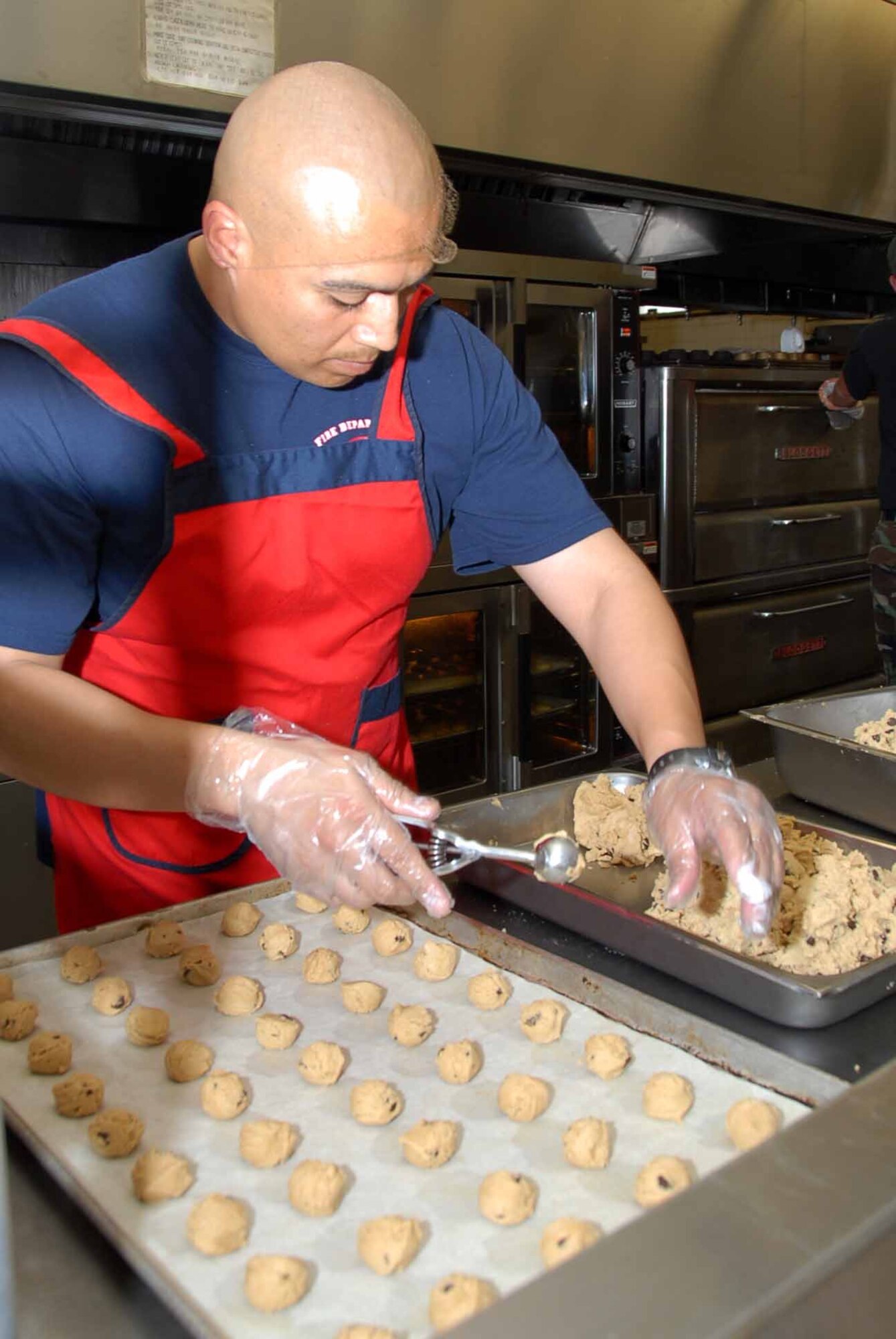 OSAN AIR BASE, Republic of Korea -- Master Sgt. Erick Nila, Osan firefighter, prepares cookies for the annual Osan Cookie Crunch program. During the holiday season, supporters bake and distribute more than 80,000 cookies to single and unaccompanied service members across the peninsula. (U.S. Air Force photo/Master Sgt. Marlin Zimmerman)
