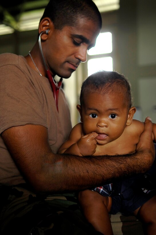 Lt. Cmdr. Sugat Patel, a doctor embarked aboard the USS Kearsarge, provides medical care to a Dominican child at the Bayaguana Sports Complex in Bayaguana, Dominican Republic, Oct. 15, 2008, as part of Continuing Promise 2008.