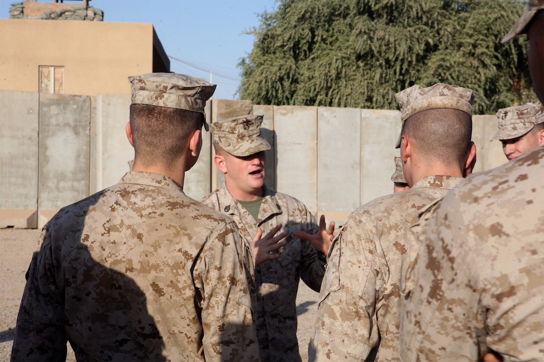 Staff Sgt. Andrew Stitt (center), a Corporals Leadership Course instructor and the assistant radio chief with Task Force 1st Battalion, 2nd Marine Regiment, Regimental Combat Team 1, explains proper drill techniques to a group of corporals Oct. 17. Marines learned how to use the historic Marine Corps NCO Sword and how to drill a squad-sized formation.