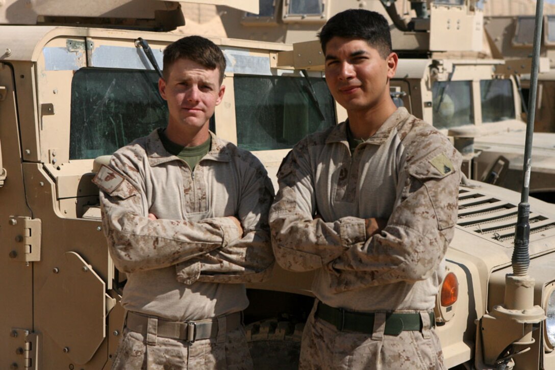 Sgt. Dustin Baker (left), a vehicle commander, and Cpl. Fernando Morales, a machine gunner, both with Civil Affairs Team 6, Detachment 1, 2nd Battalion, 11th Marine Regiment, Regimental Combat Team 5, pose for a photograph at Haqlaniyah, Iraq, Oct. 14. Baker and Morales are both individual augments who were called back to the Marine Corps to serve in Iraq.::r::::n::