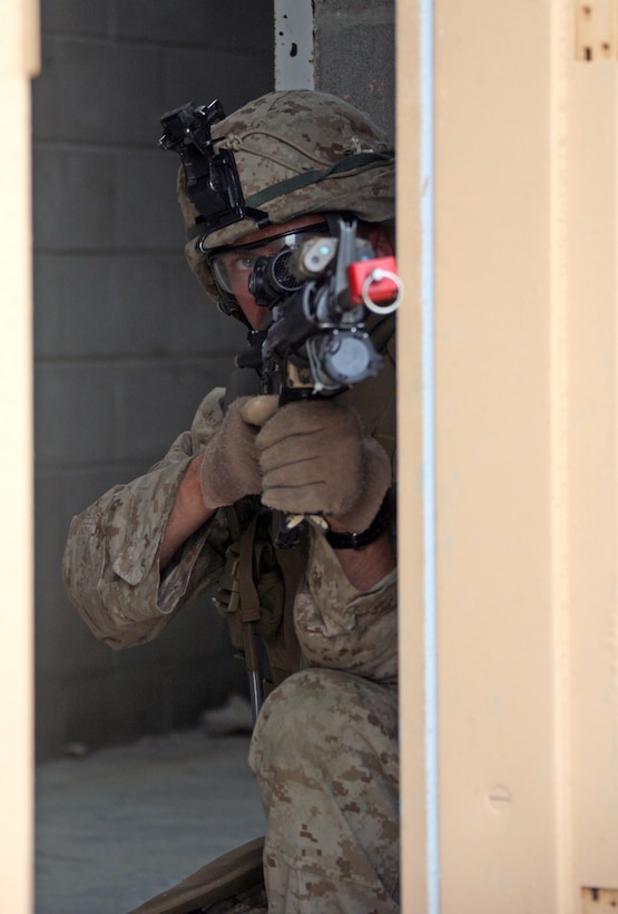 Pfc. Michael Baker, a 20 year-old Marine from Moody, Texas, aims in and takes cover behind an open door, during a helicopter-raid training event held at the Military Operations in Urban Terrain training facility aboard Camp Lejeune, N.C., Oct 17, 2008. Baker, who has been in the Marine Corps for only 8 months, is part of the Assault Element of Helo Company, comprised of the 2nd Platoon, Lima Co., 3rd Battalion, 2nd Marine Regiment, 22nd Marine Expeditionary Unit. The Marines attended the course to train on the proper techniques for performing a raid. The 22nd MEU is scheduled to deploy for six-months next year. (Official Marine Corps Photo by Cpl. Theodore W. Ritchie)::r::::n::