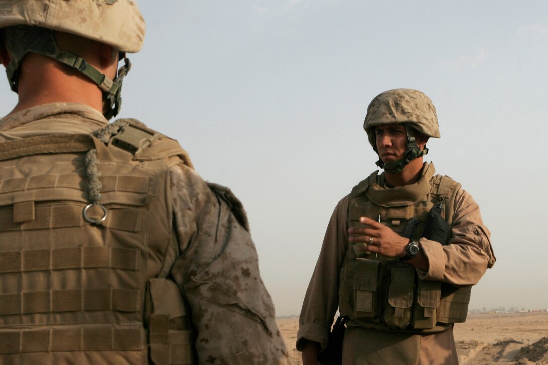 Staff Sgt. Bryan Spencer, Combat Logistics Battalion 5 Engineer Company operations platoon sergeant, briefs heavy equipment operators and combat engineers on the day’s mission to level approximately 1,000 meters of berm along Wolverine Way, a road stretching from Camp Baharia to the outskirts of Fallujah, Iraq, Oct. 18.  Spencer, for Texarkana, Texas, and other Marines demolished five miles of berm along the road during about a week as part of a larger project to demilitarize Fallujah and turn control of the Fallujah area to Iraqi government control.