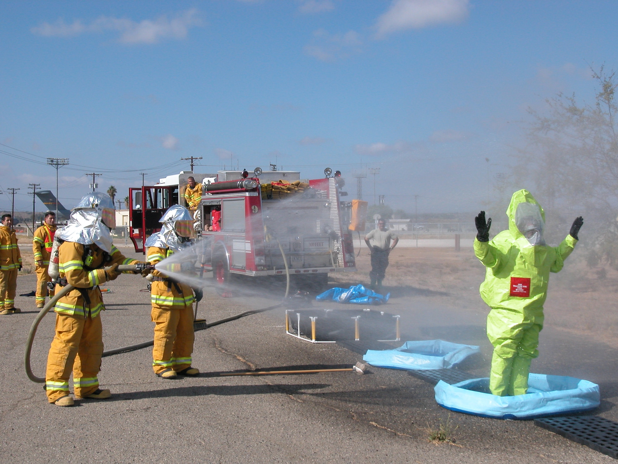 Senior Airman Travis Dean, 452nd Fire Department, hoses down Senior Airman Chris Valenzano, 163 EM Flight, in the decontamination area. Emergency management, bioenvironmental and the fire department work hand-inhand to ensure hazardous materials are properly identified, contained and disposed of. (U.S Air Force photo by Senior Airman Kara McGrath)